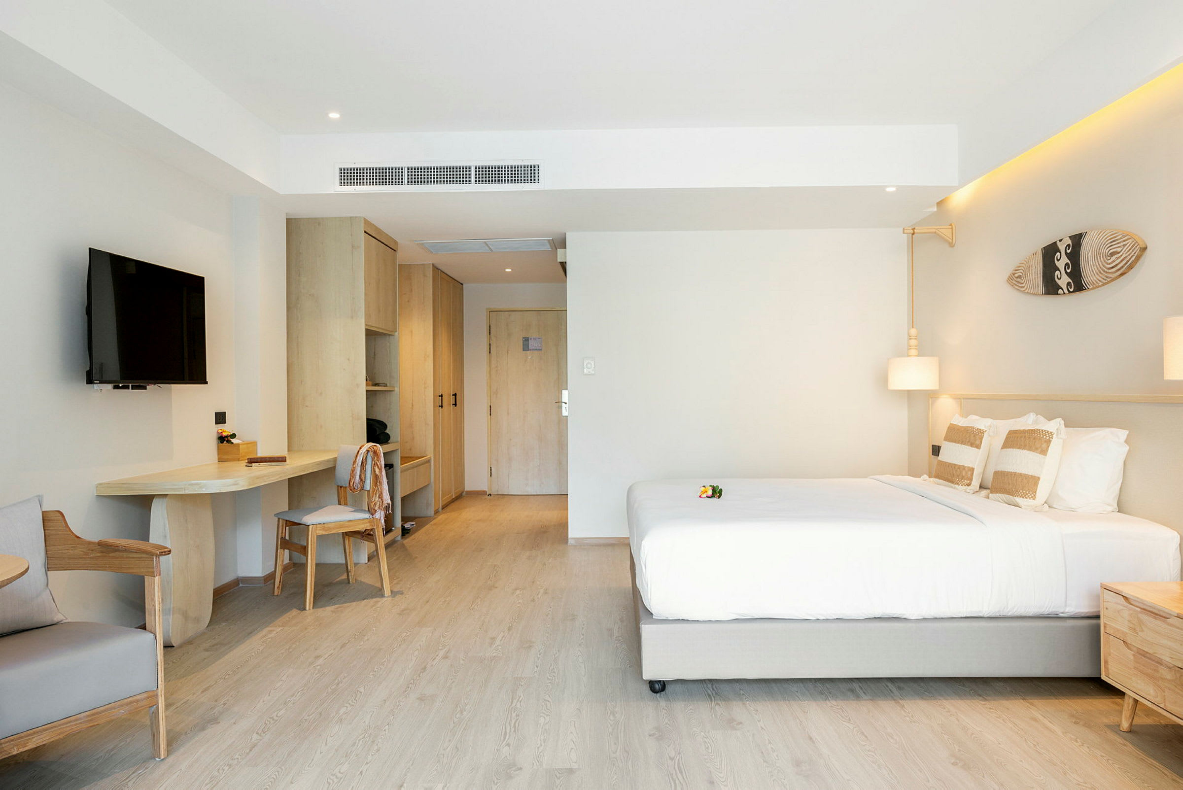 Ett modernt hotellrum med en dubbelsäng, TV, skrivbord och garderober. (AI-genererad text)