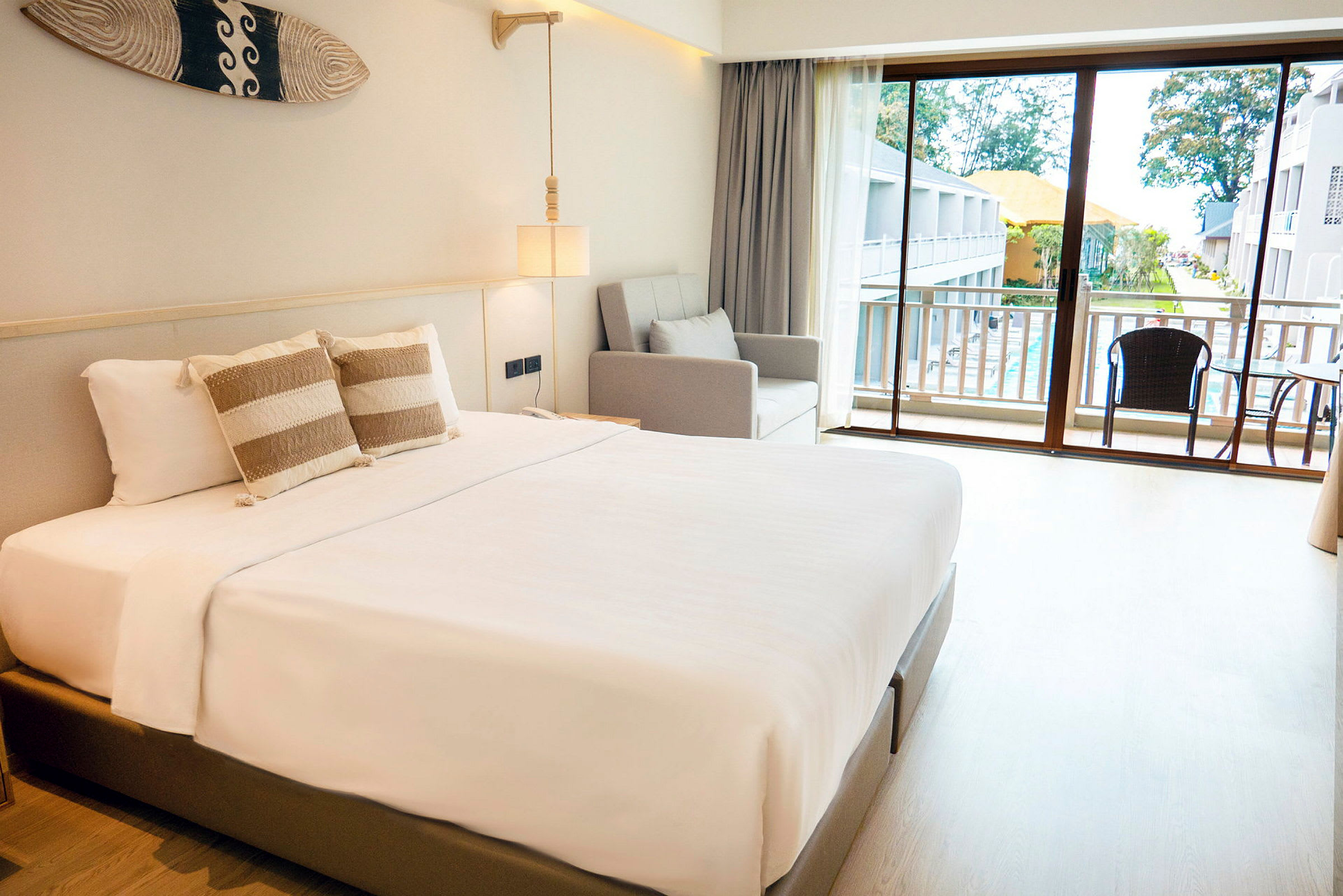 Ett hotellrum med en dubbelsäng, soffa och balkong med utsikt. (AI-genererad text)