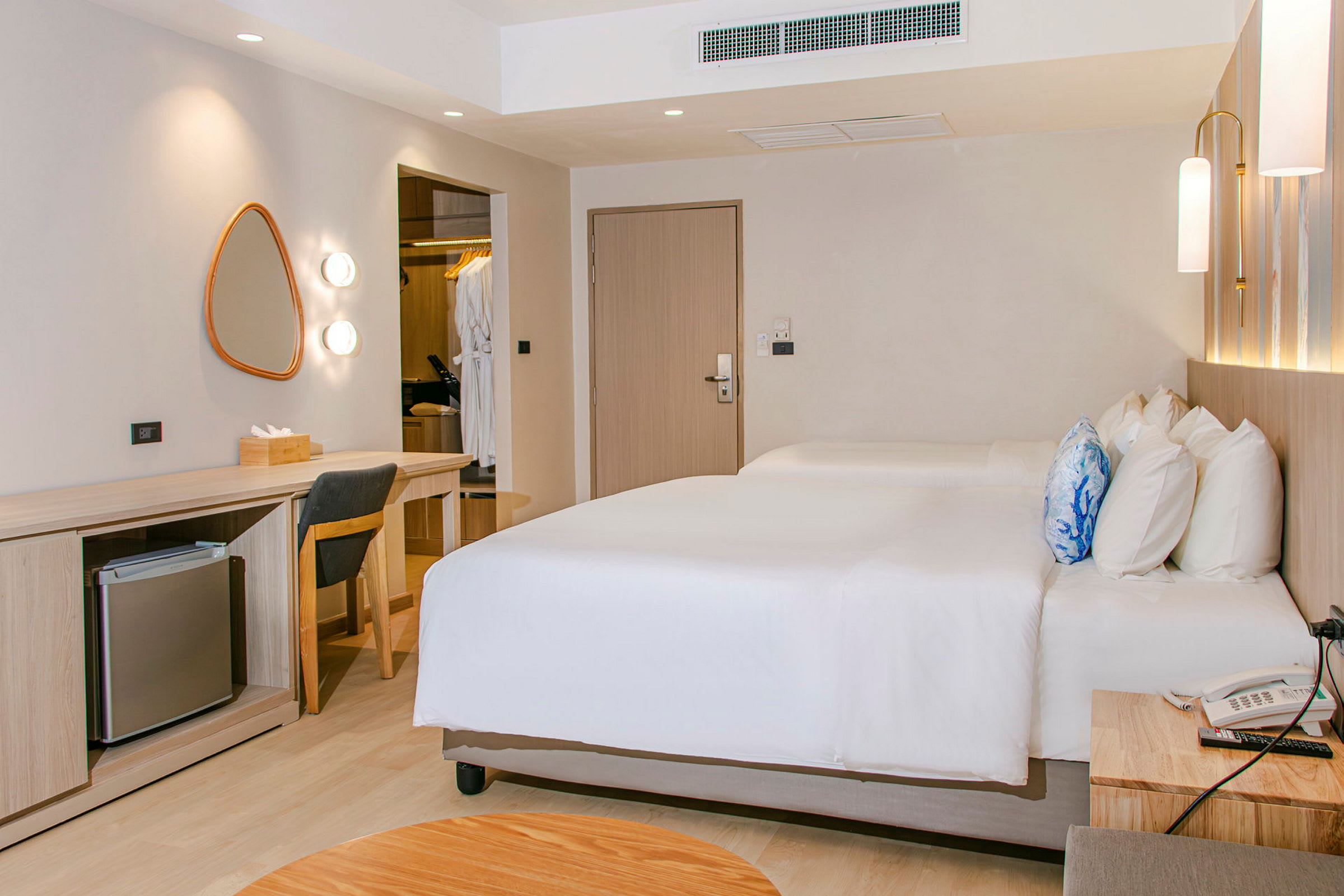 Ett hotellrum med två sängar, ett skrivbord och en garderob. (AI-genererad text)