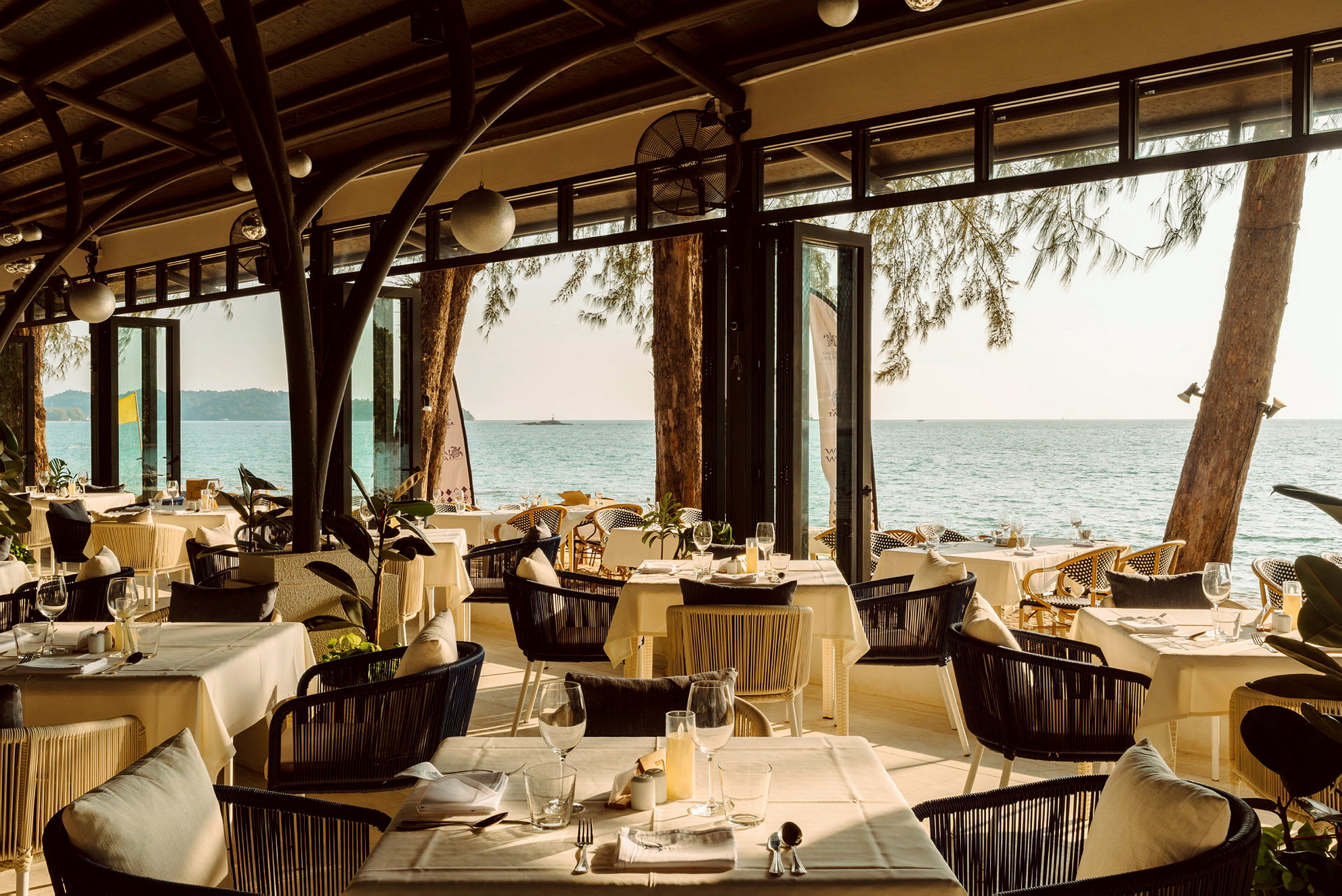 En restaurang med dukade bord och utsikt över havet. (AI-genererad text)