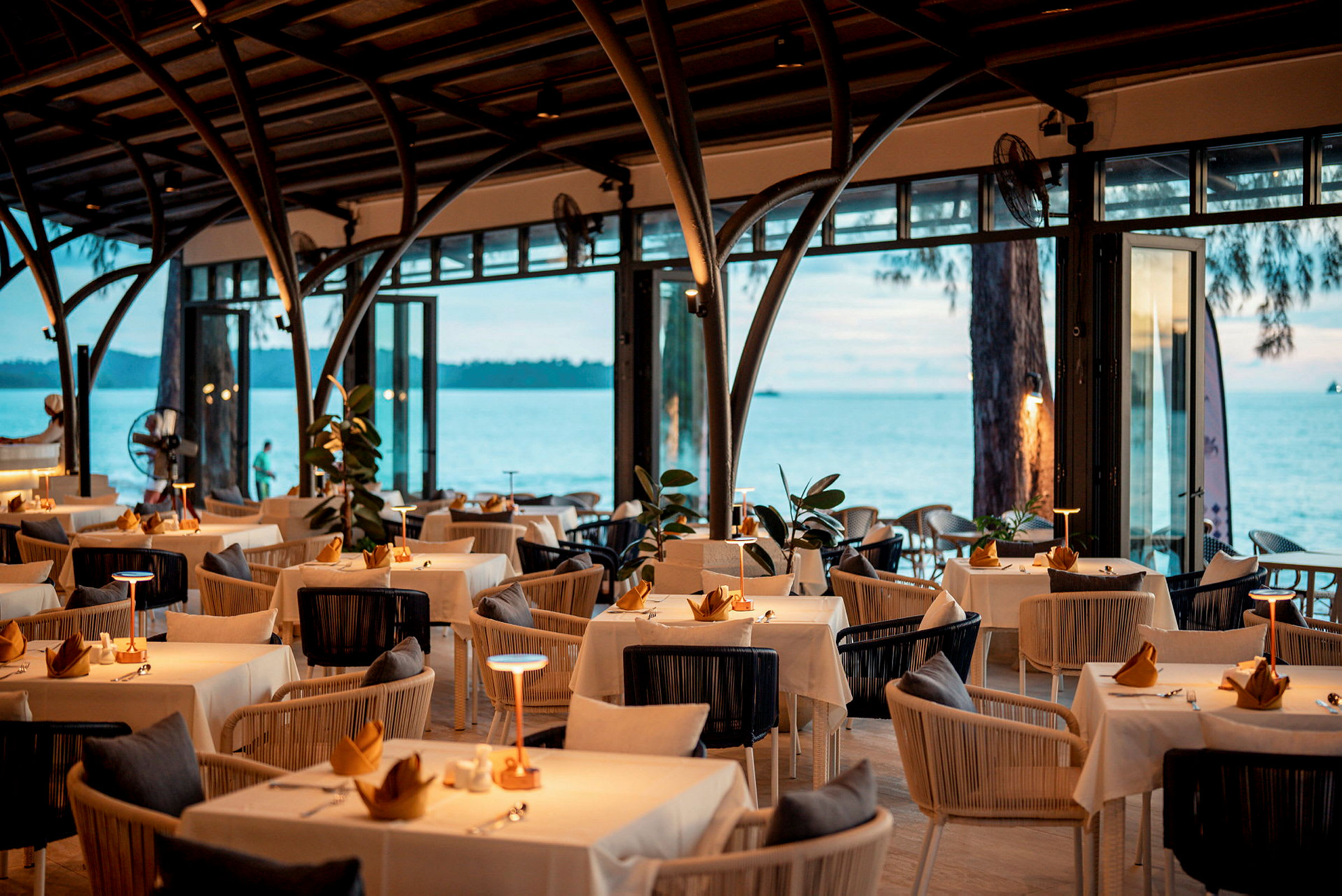 En elegant restaurang med dukade bord och havsutsikt. (AI-genererad text)