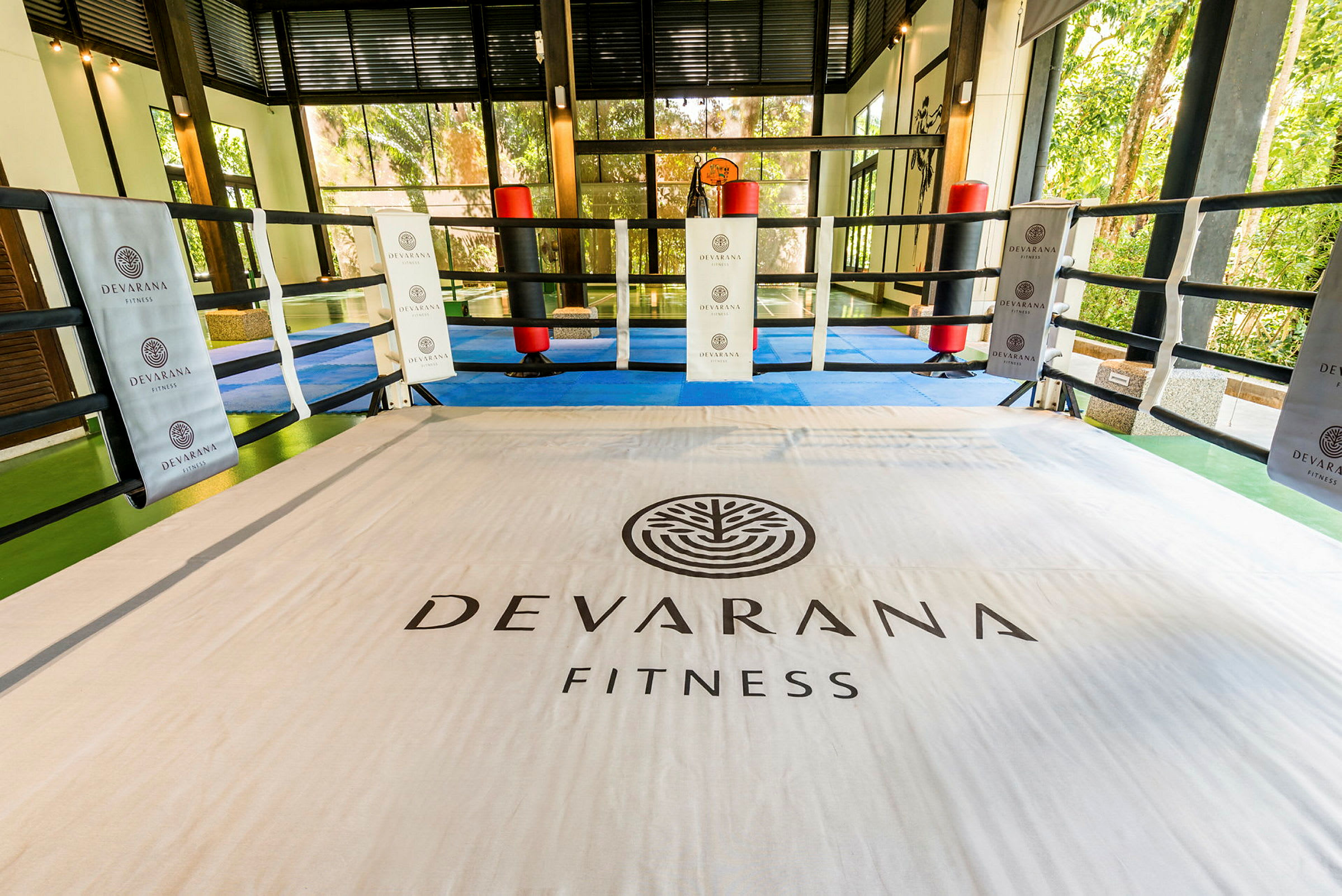 En inomhus träningssring märkt med texten "Devarana Fitness", omringad av rep. (AI-genererad text)