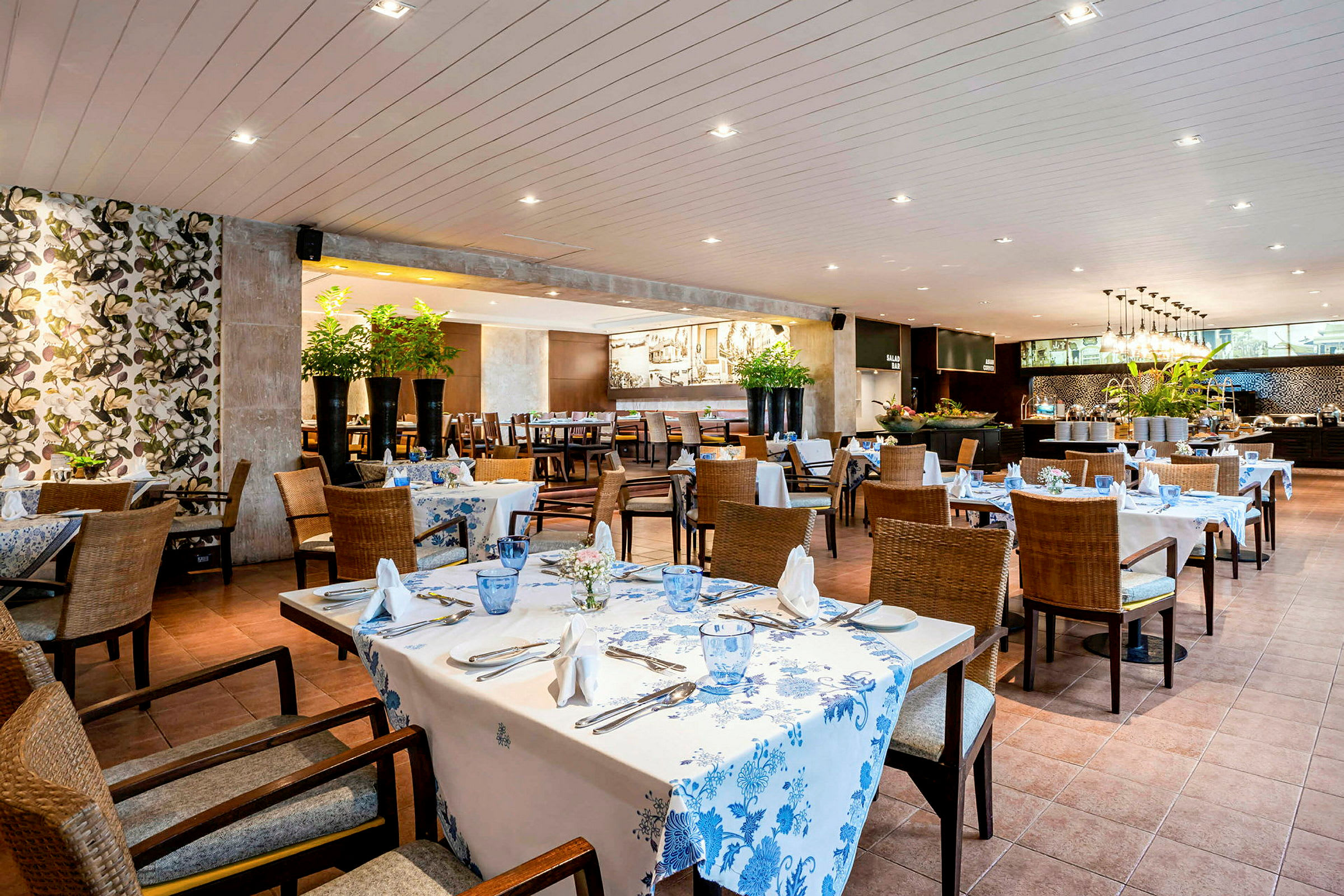 En restaurang med dukade bord, blommiga dekorationer och moderna möbler. (AI-genererad text)
