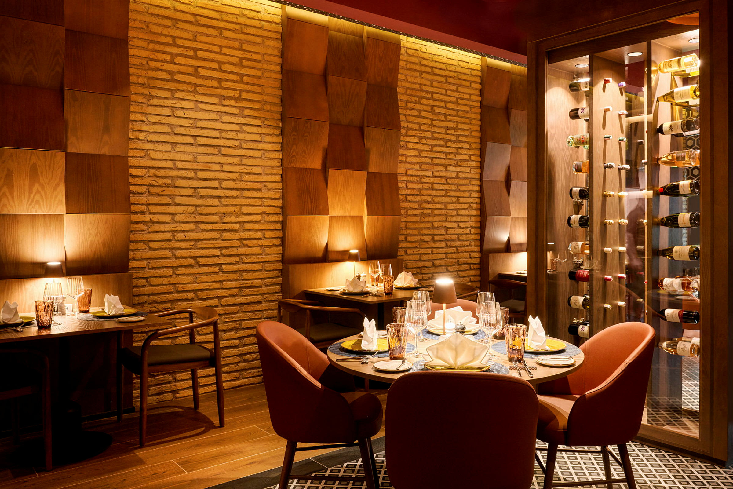 En elegant restauranginteriör med dukade bord och mjuk belysning mot väggar av tegel och träpanel. (AI-genererad text)