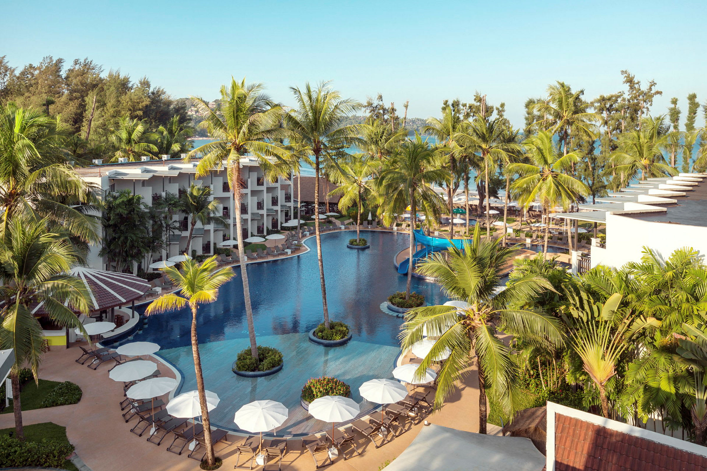 En översikt av en hotellresort med pool och palmer. (AI-genererad text)