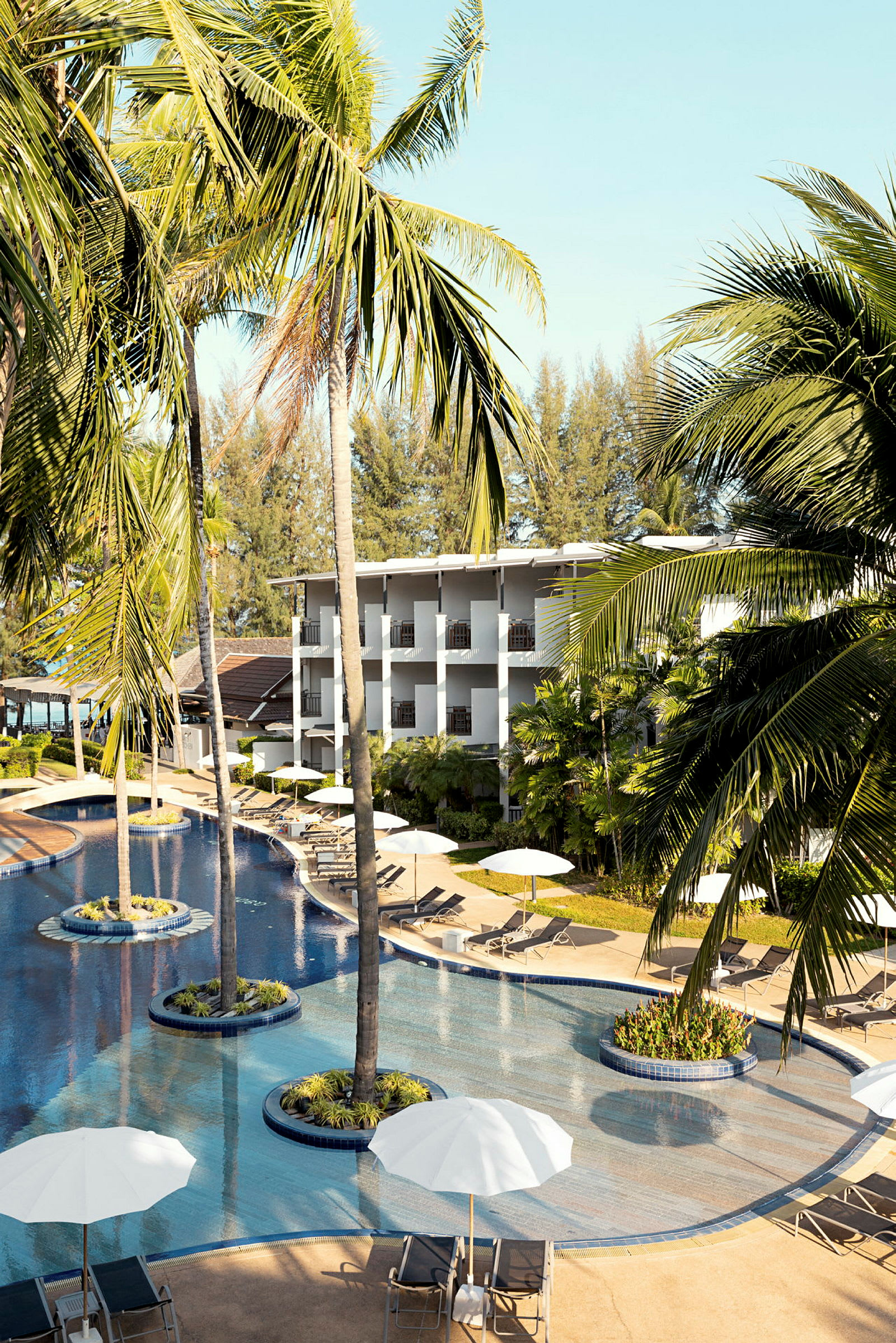 Hotell med pool och omgivande palmträd. (AI-genererad text)