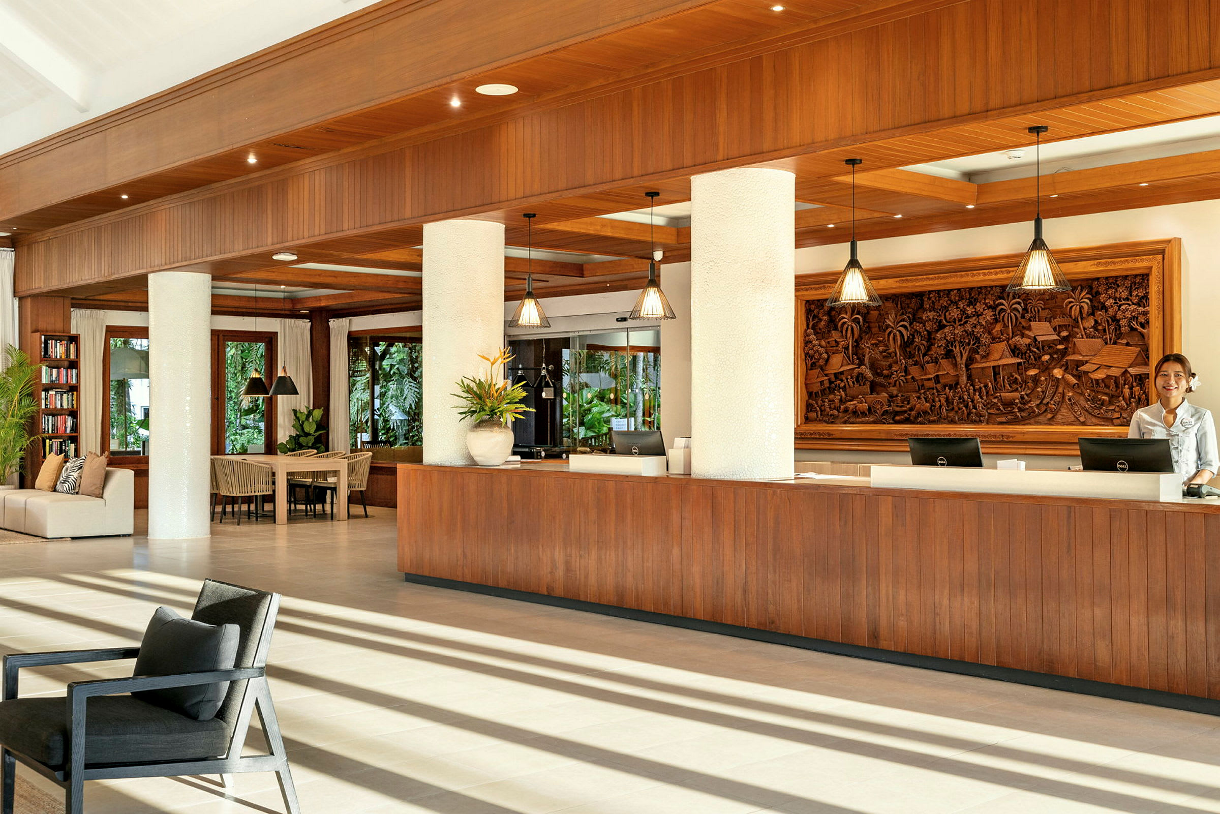 Reception i ett modernt hotell med trädetaljer och dekorativt snideri på väggen. (AI-genererad text)