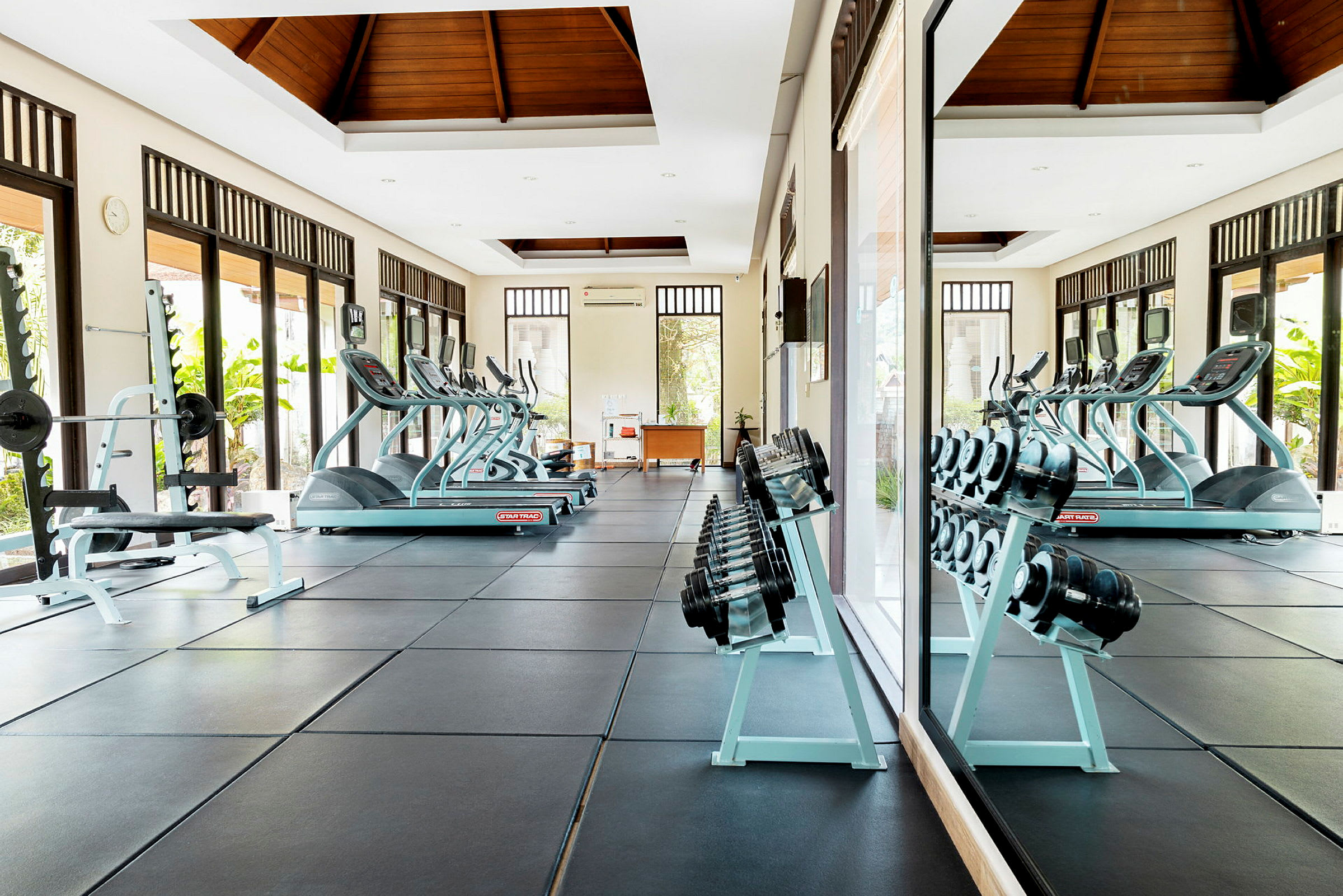 Ett gym med träningsutrustning, såsom löpband, hantlar och bänkpress. (AI-genererad text)