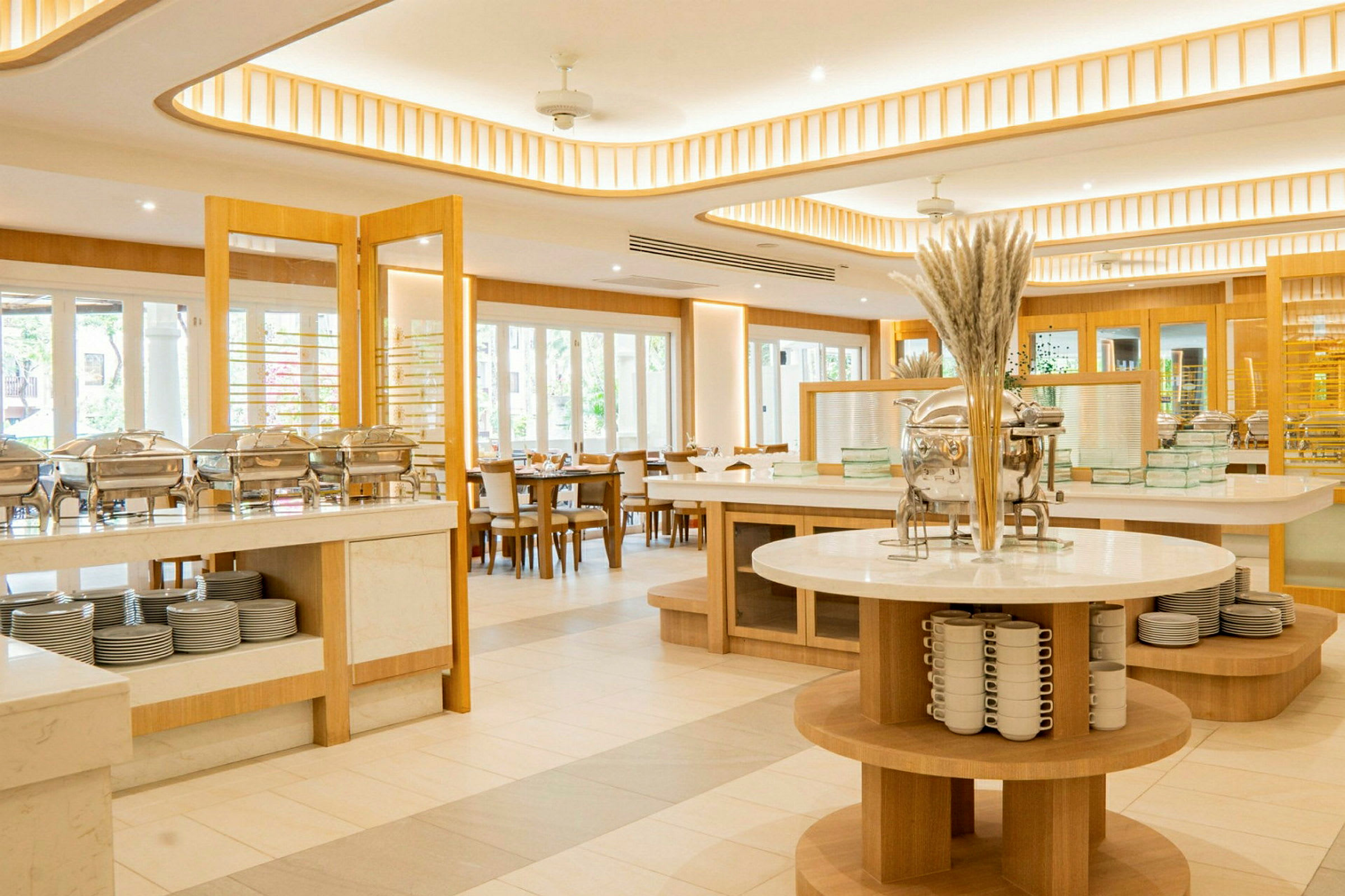 Ljust inredd bufférestaurang med moderna möbler och serveringsstationer. (AI-genererad text)