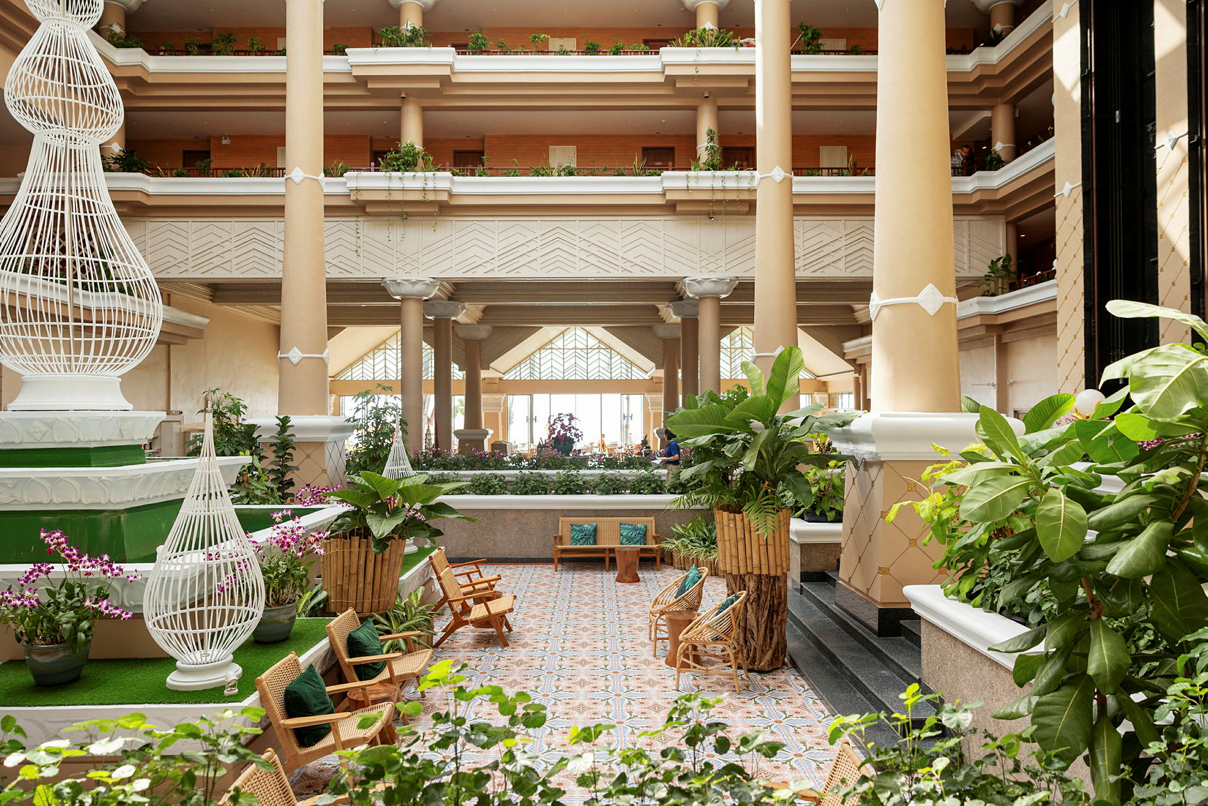 Ljus och rymlig hotellobby med gröna växter och sittplatser. (AI-genererad text)
