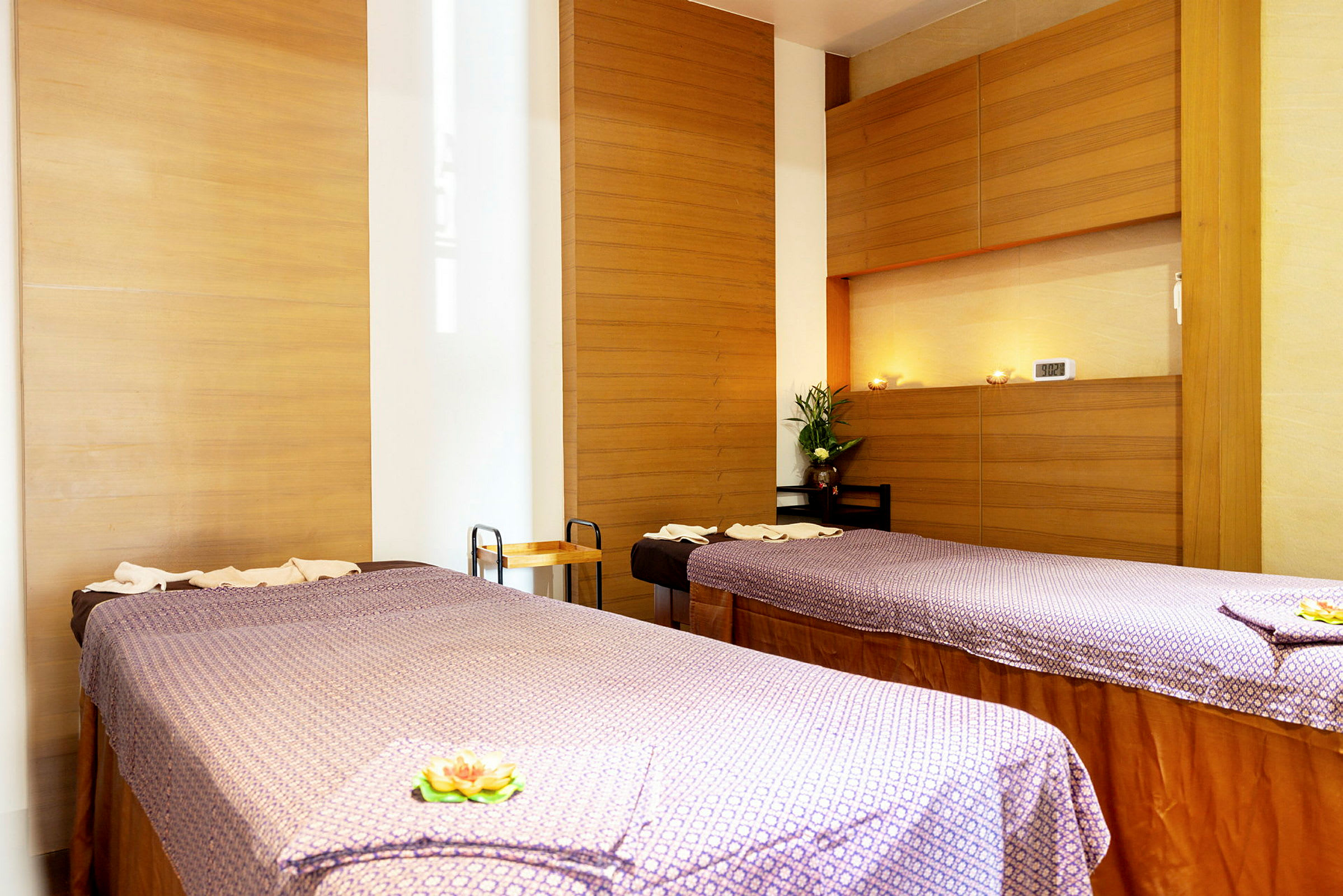 Två massagebänkar i ett rum med träpaneler och avslappnande inredning. (AI-genererad text)