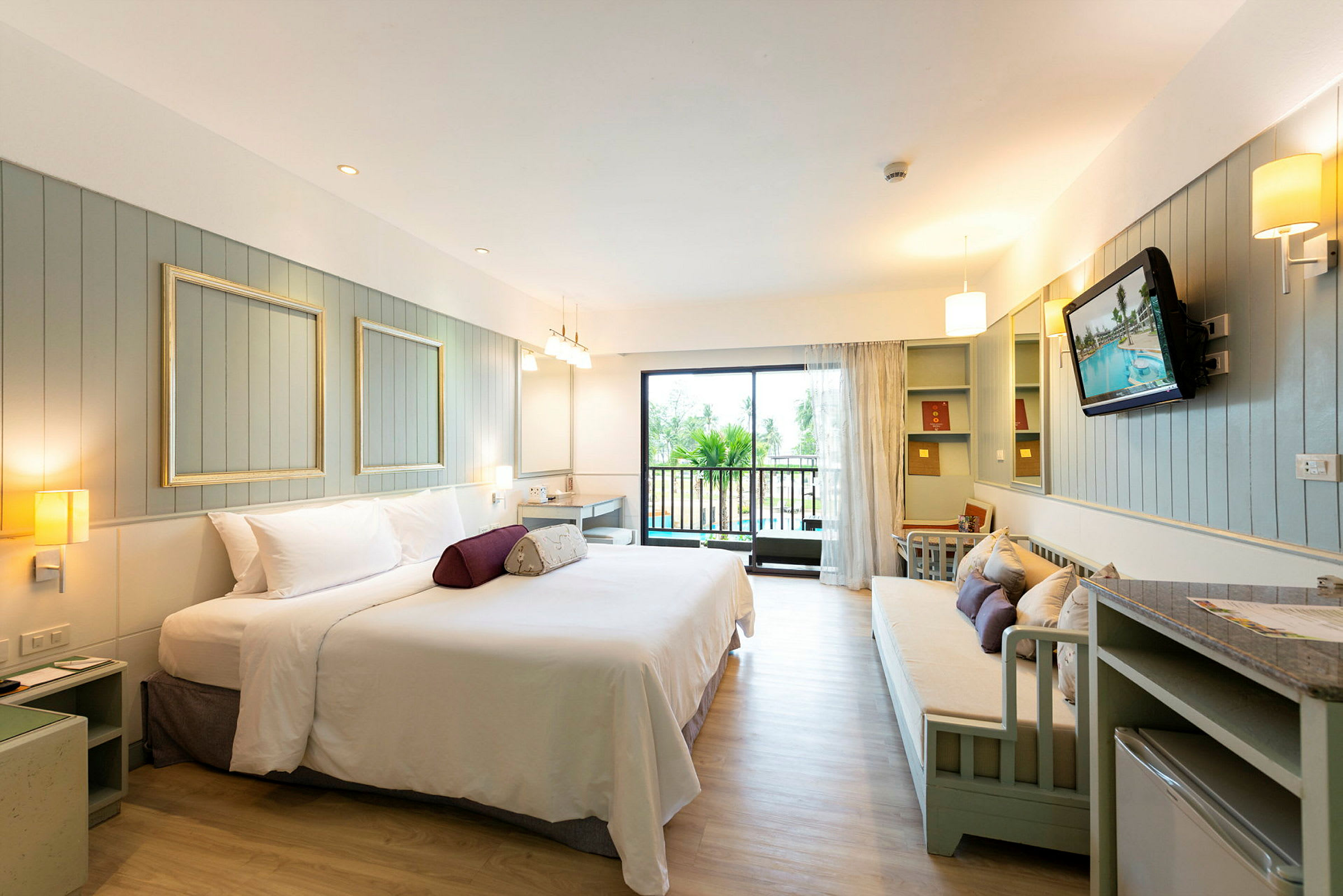Ett rymligt hotellrum med modern möblering och en balkong. (AI-genererad text)