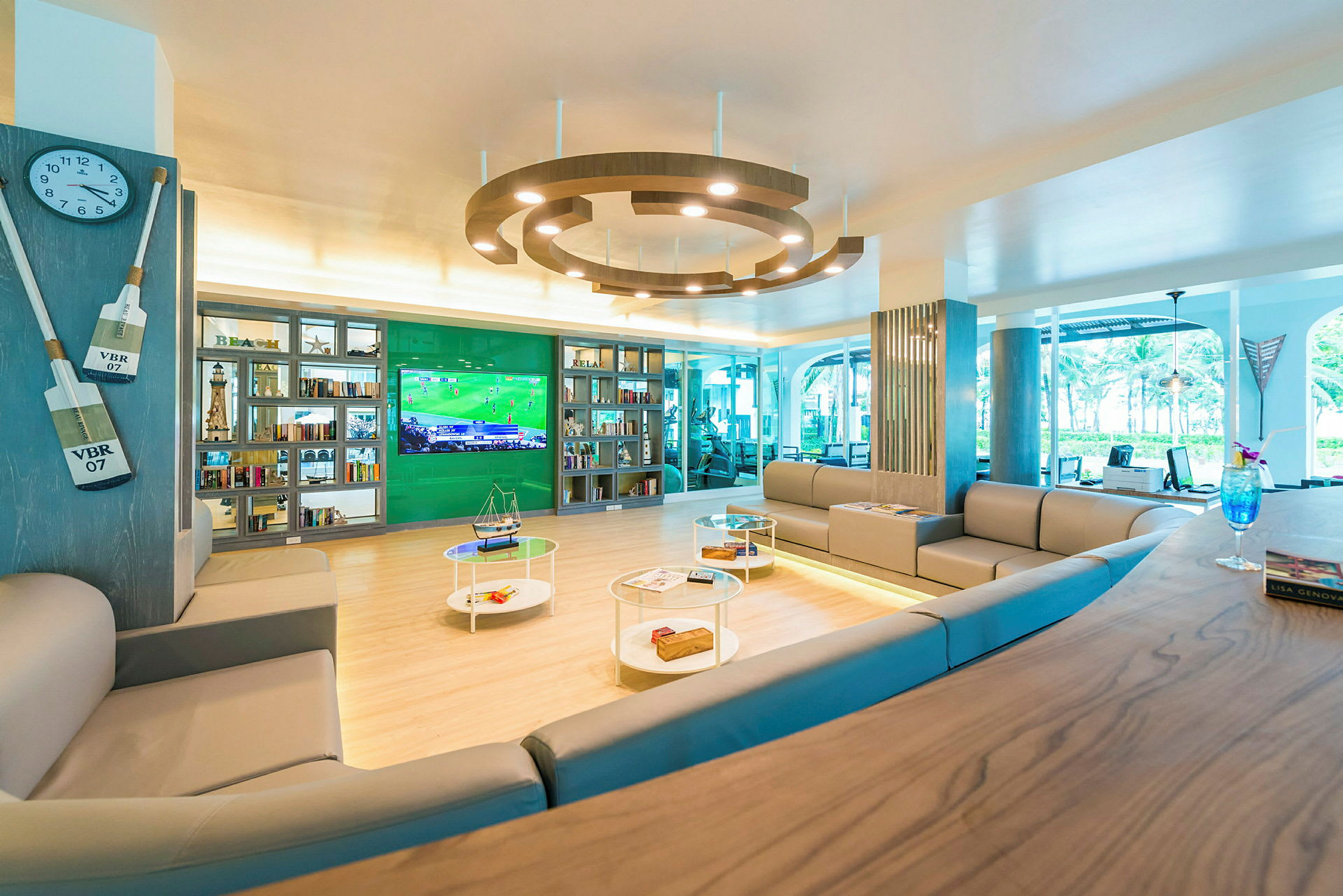 Loungeområde med soffor, hyllor och en stor TV. (AI-genererad text)