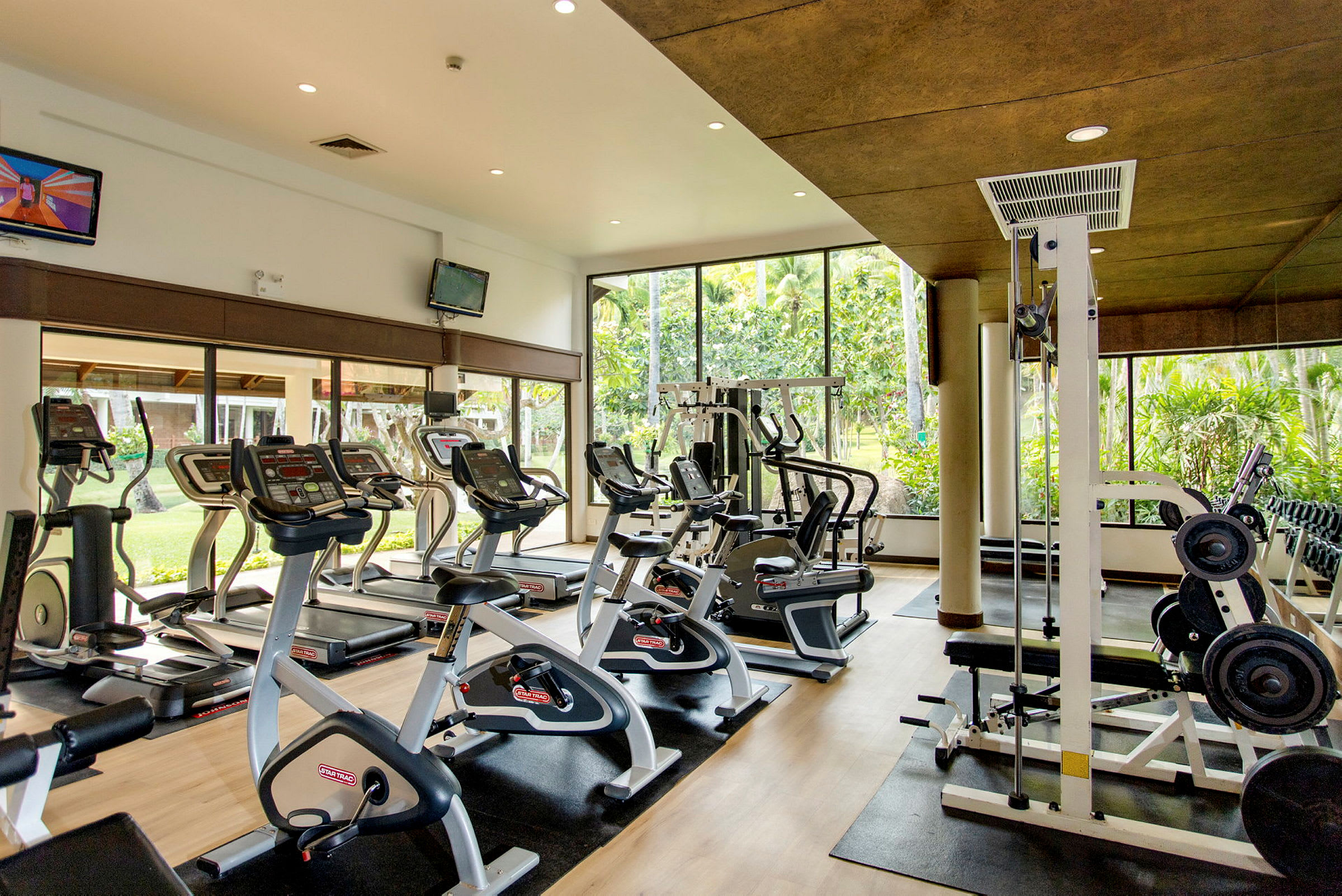 Gym med träningsmaskiner och stora fönster. (AI-genererad text)
