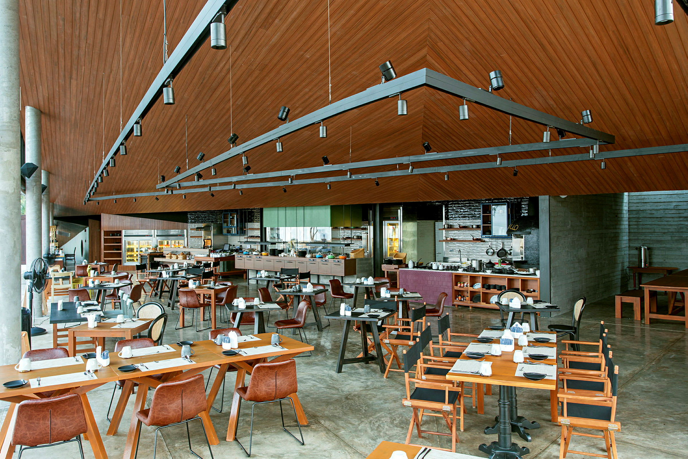 En rymlig restaurang med trädetaljer, moderna möbler och dukade bord. (AI-genererad text)