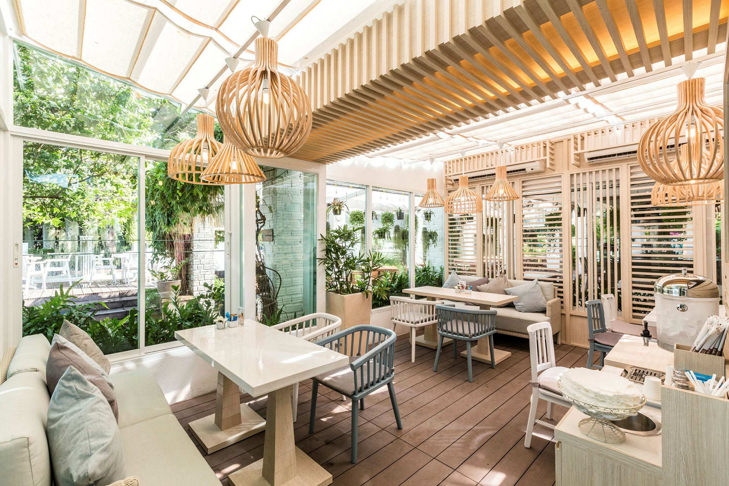En modern utomhusrestaurang med naturmaterial och växter. (AI-genererad text)