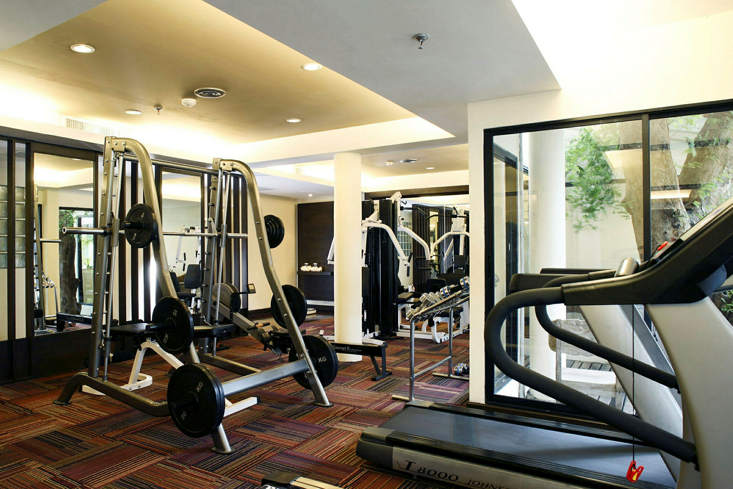 Ett gym med träningsutrustning inklusive vikter och löpband. (AI-genererad text)