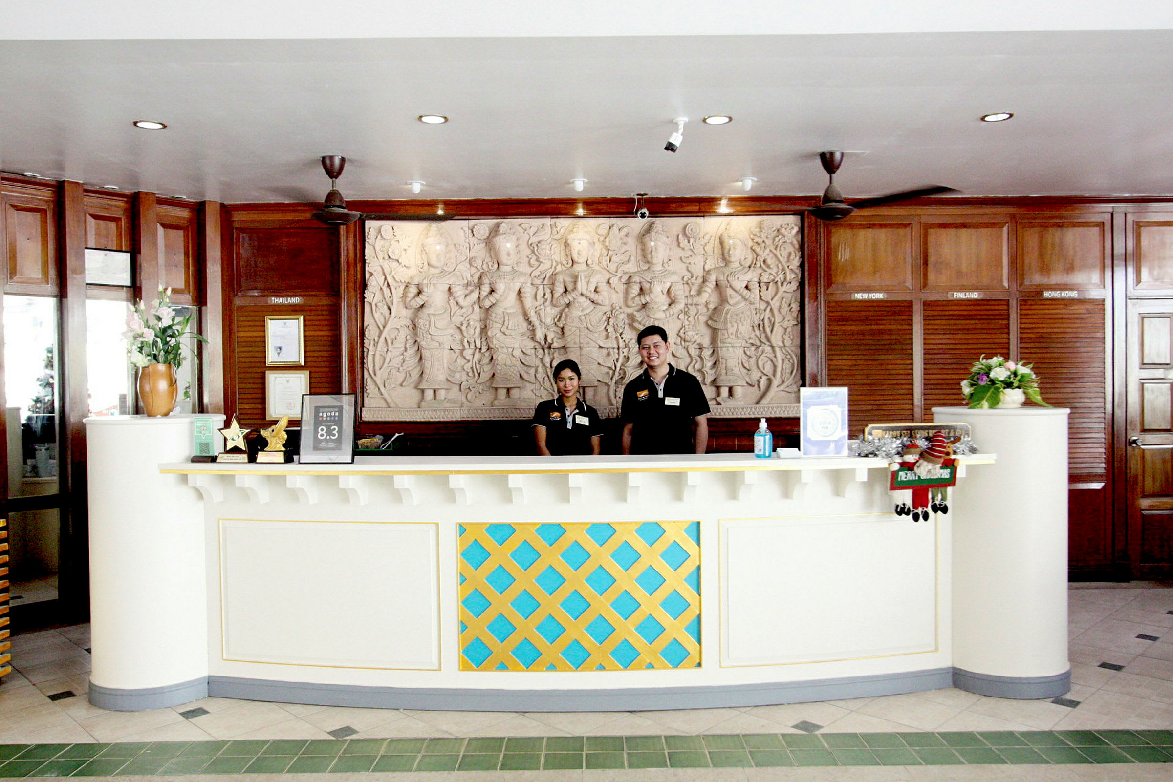 Reception med ett dekorativt desk och detaljerad väggutsmyckning. (AI-genererad text)