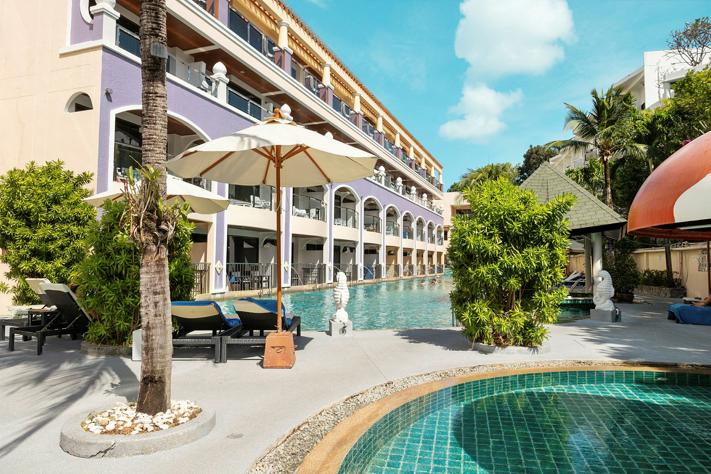 En pool med solstolar och parasoller nära en hotellbyggnad. (AI-genererad text)