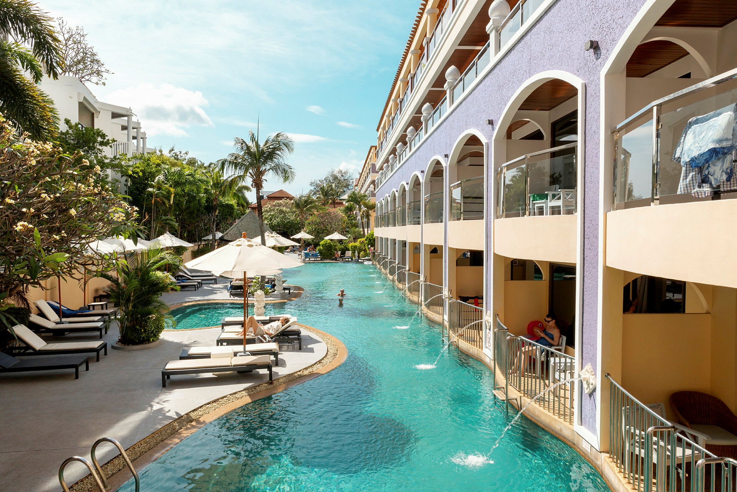 En hotellpool omgiven av solstolar och palmer. (AI-genererad text)