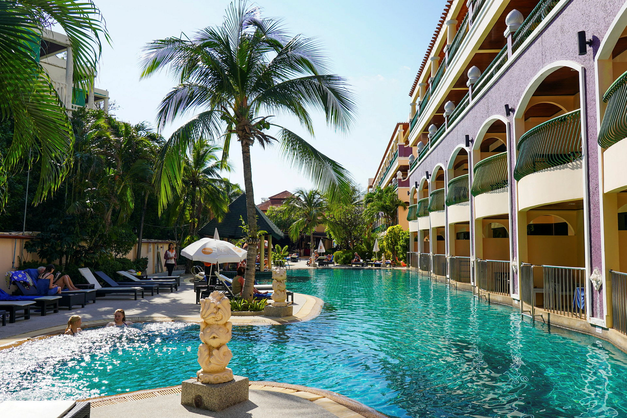 Bild av en pool vid ett hotell med solstolar och palmträd. (AI-genererad text)