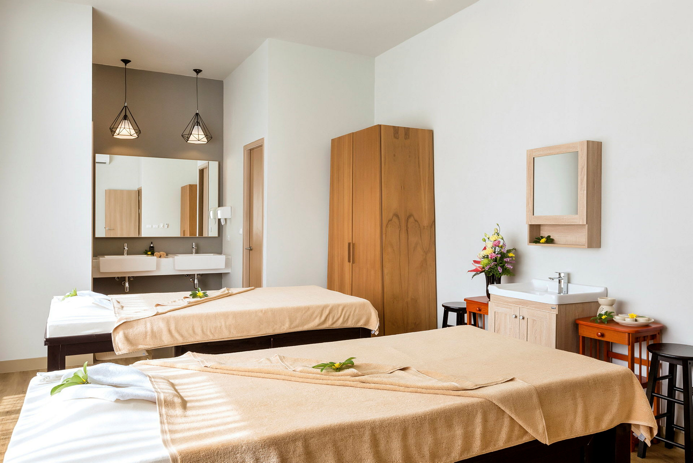 Två massagebänkar i ett ljust och smakfullt inrett rum. (AI-genererad text)