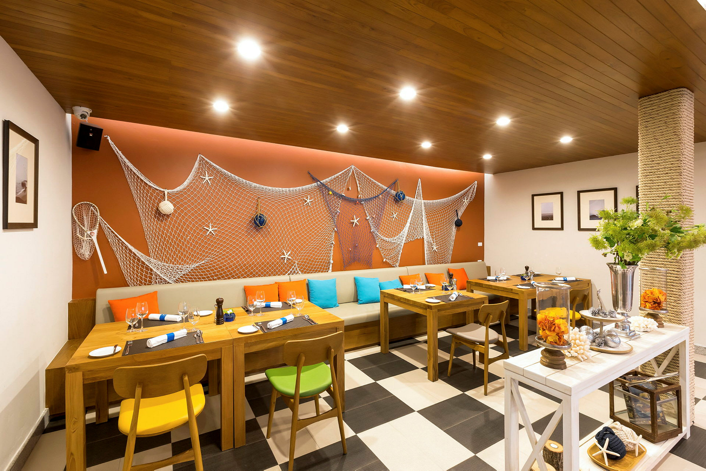 Restaurang med marin inredning, träbord och färgglada stolar. (AI-genererad text)