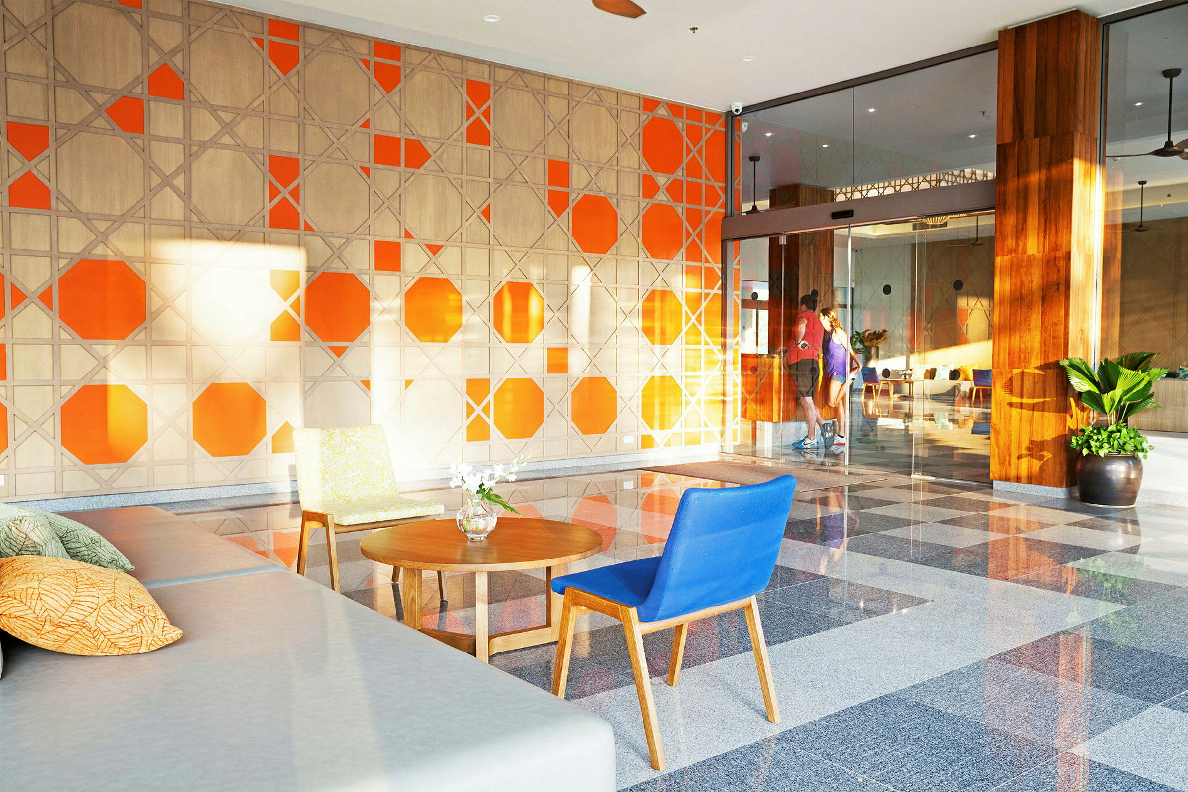 Lobbyn med en orange och beige väggdesign och sittmöbler. (AI-genererad text)