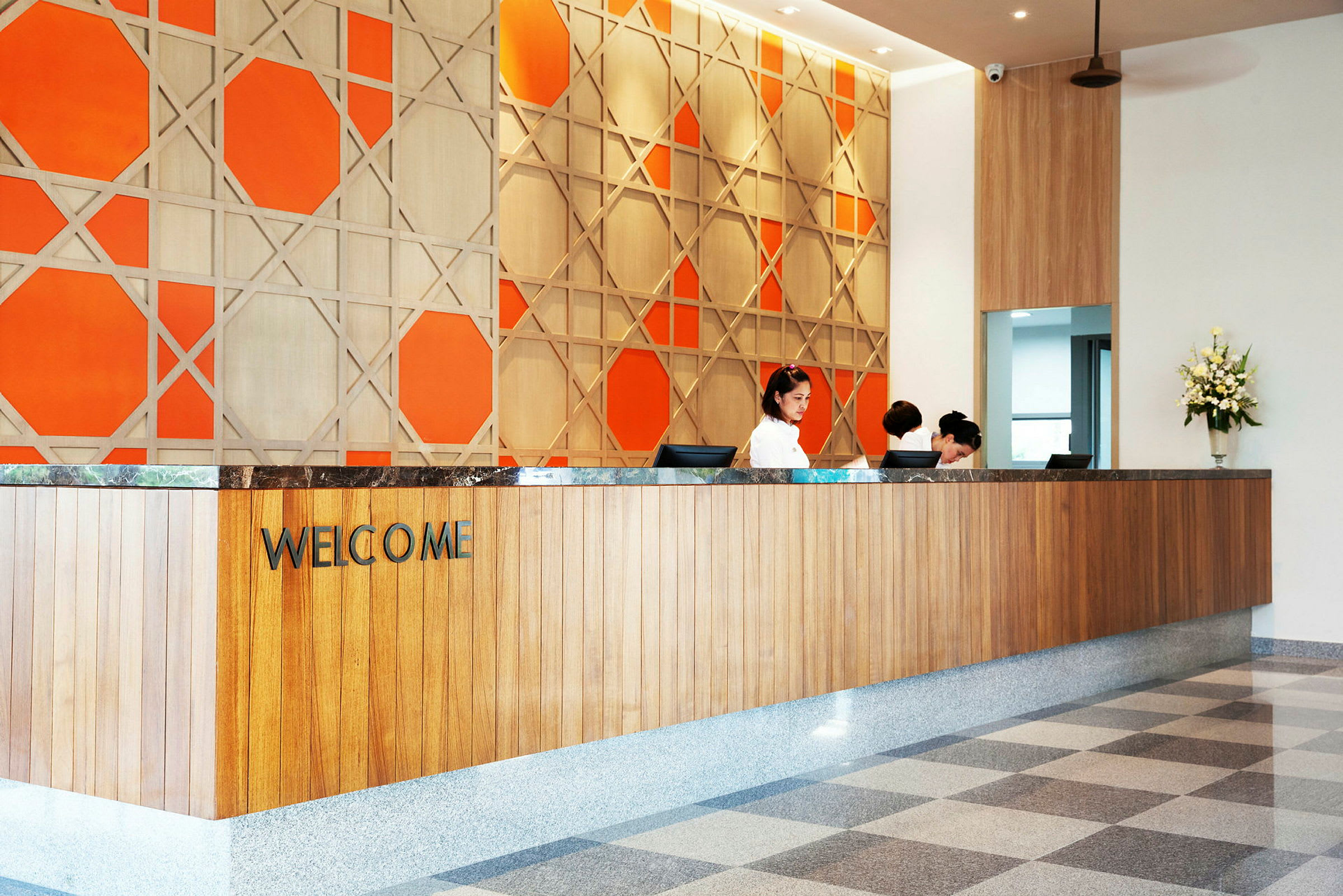 Reception med välkomstskylt och dekorativ orange vägg. (AI-genererad text)