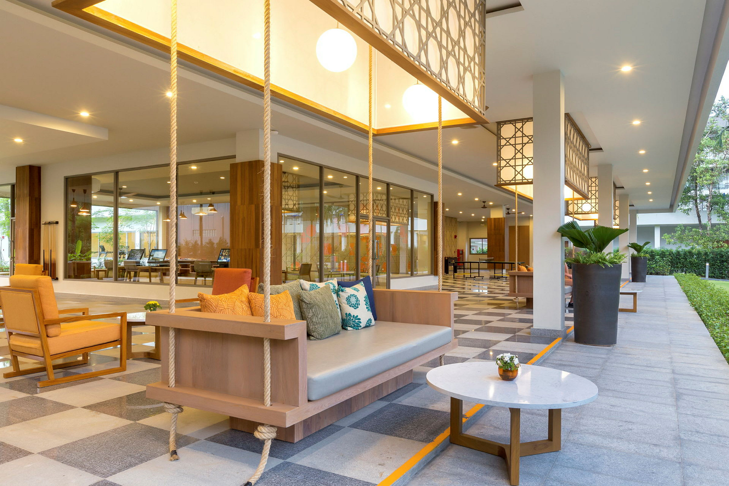 En hotellobby med sittplatser, svängbänk och bord. (AI-genererad text)