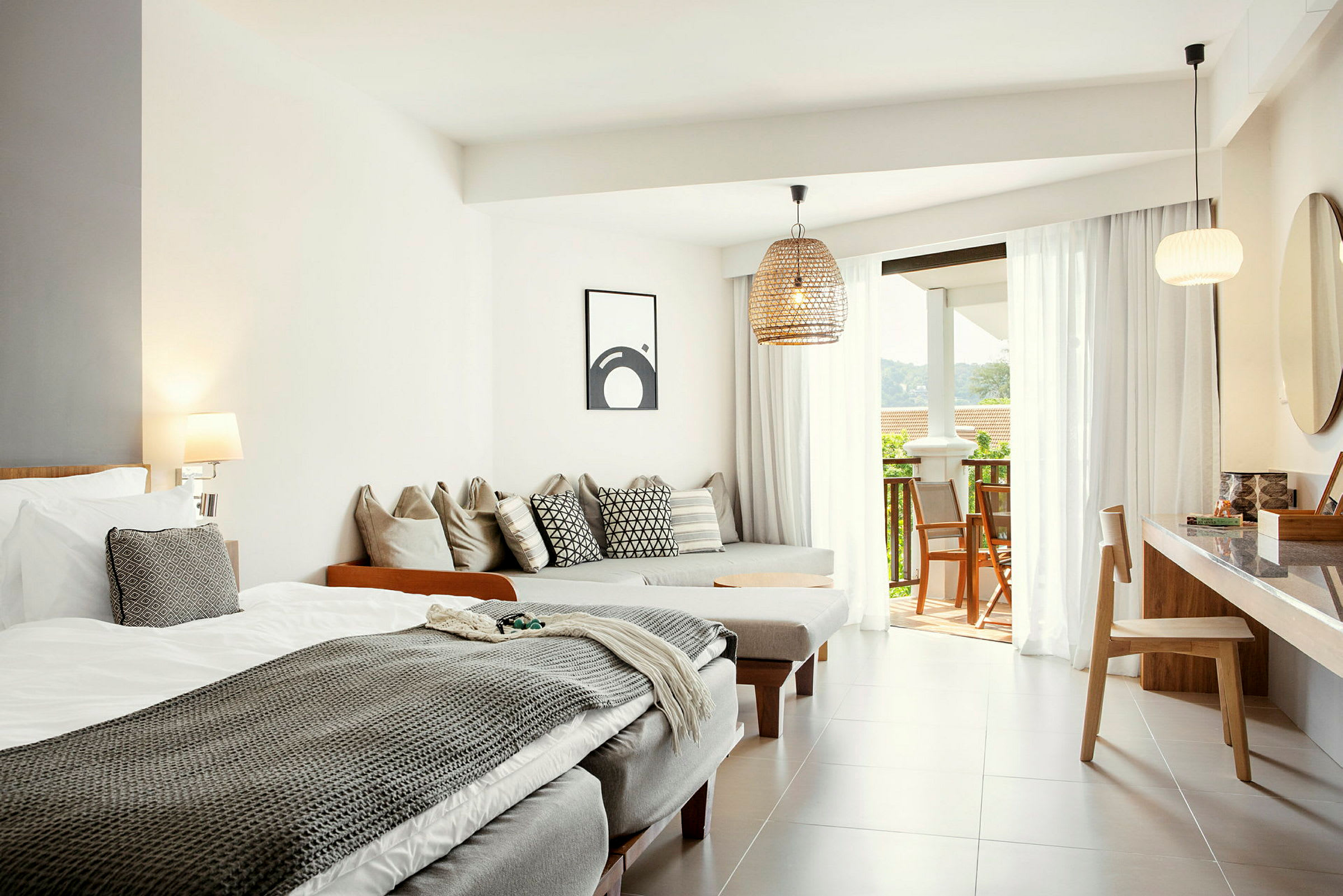 Ljusa och moderna hotellrum med säng, sittmöbler och öppning till balkong. (AI-genererad text)