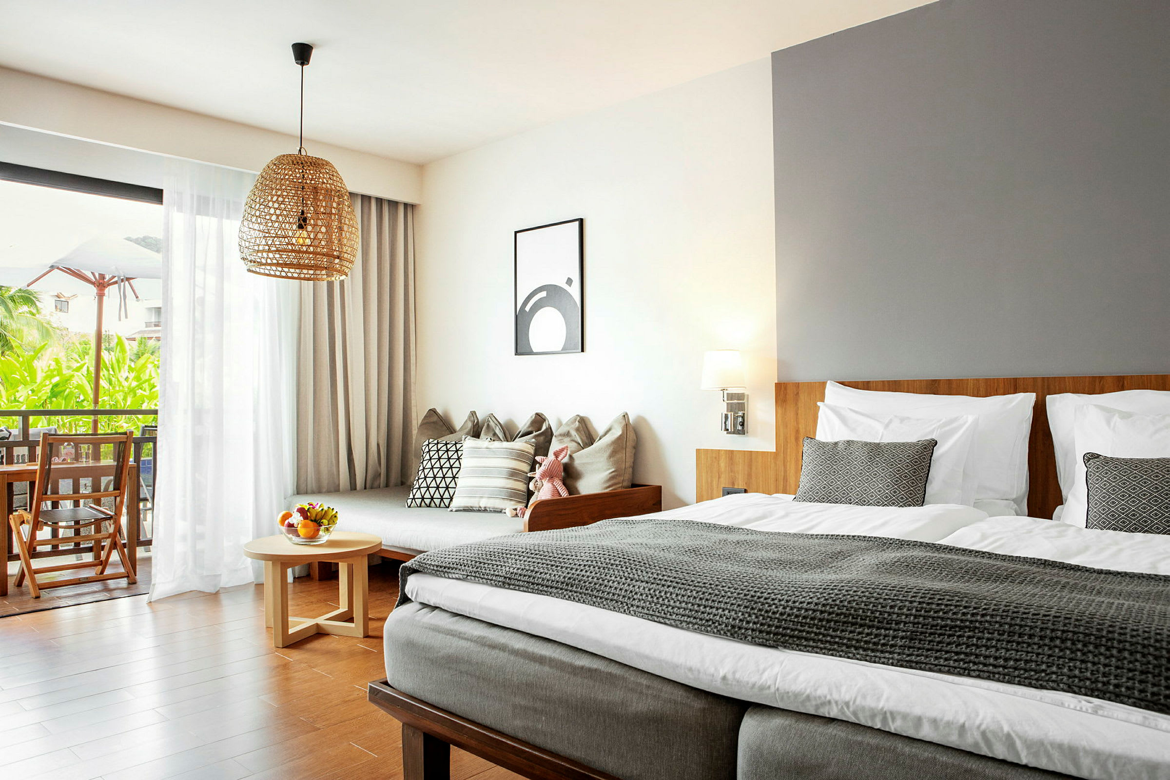 Modernt inrett hotellrum med säng, soffa och balkong med utsikt. (AI-genererad text)