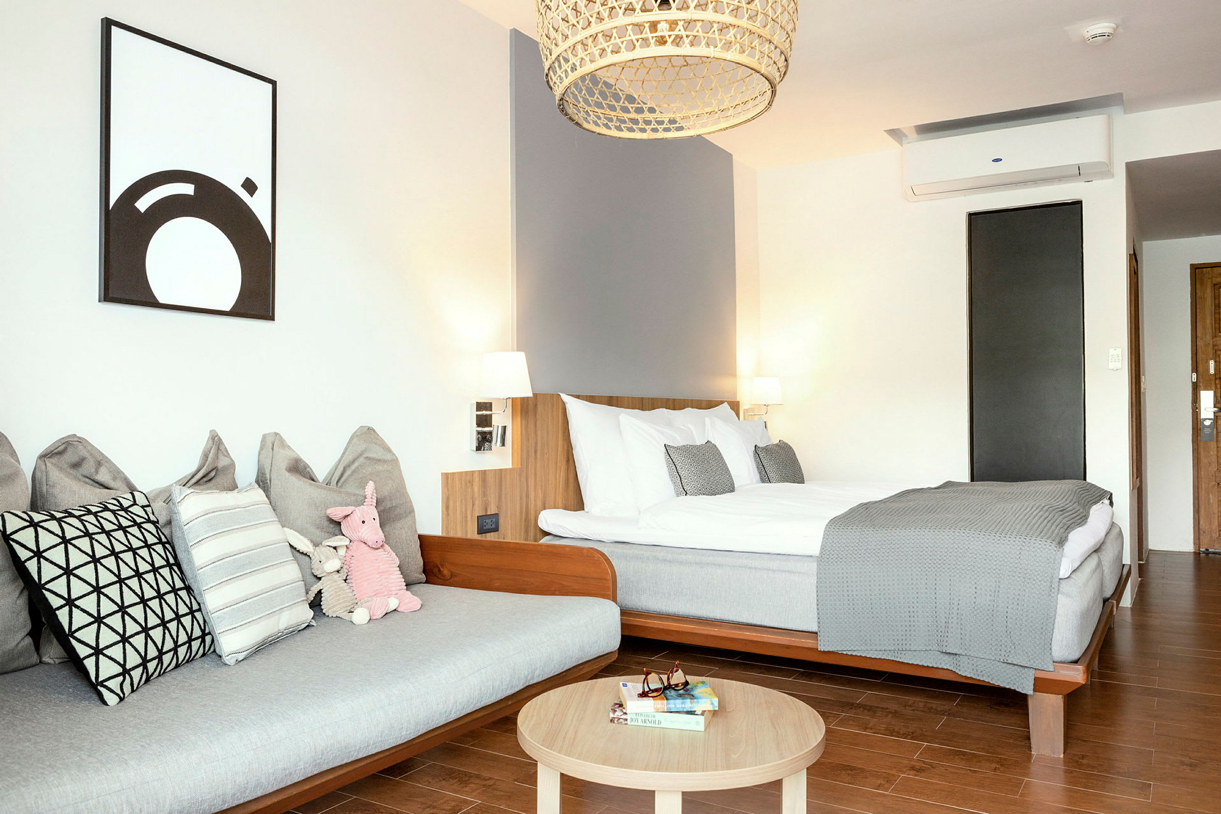 Ett modernt hotellrum med en säng, en soffa och ett träbord. (AI-genererad text)