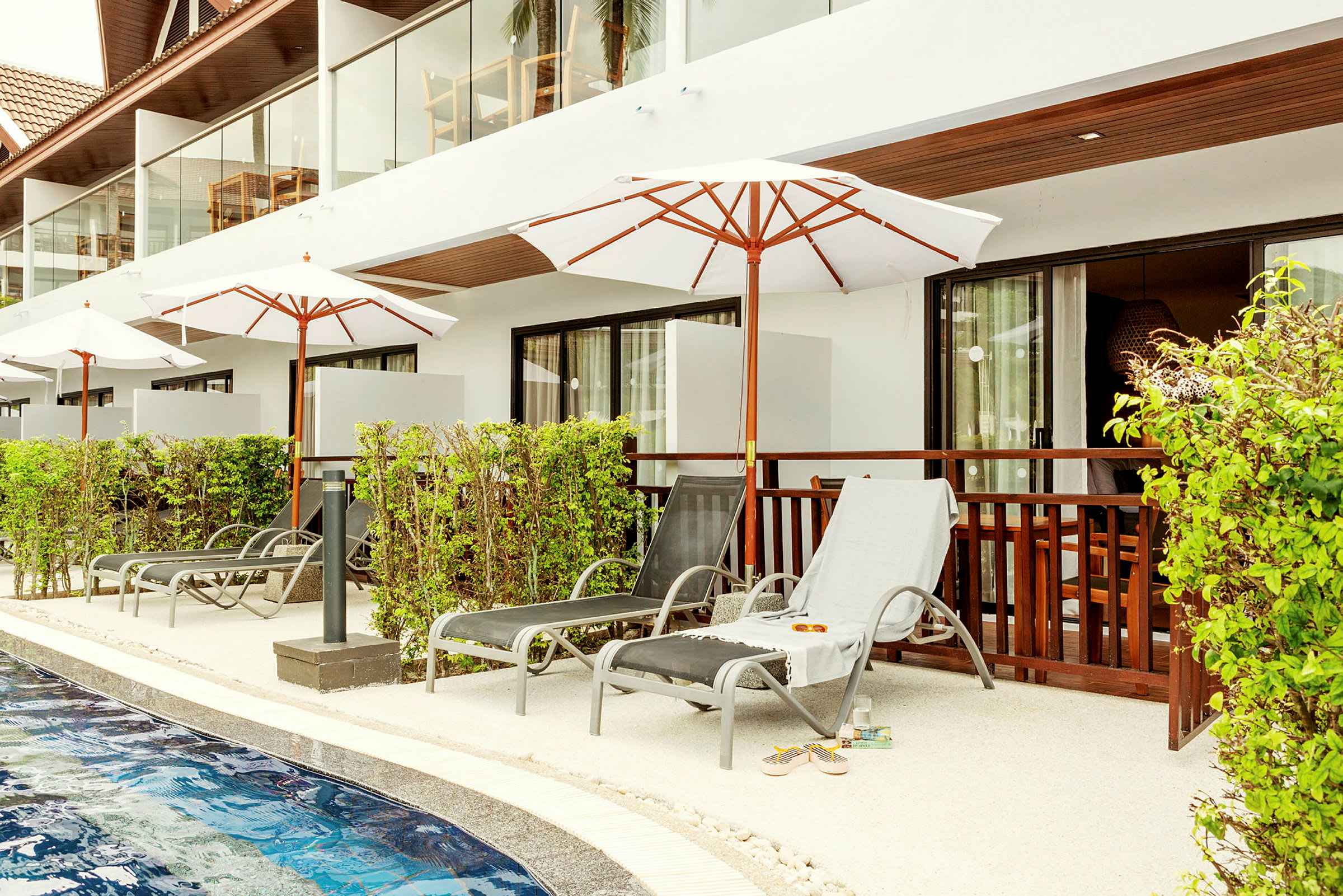 Solstolar vid en pool utanför hotellets rum. (AI-genererad text)