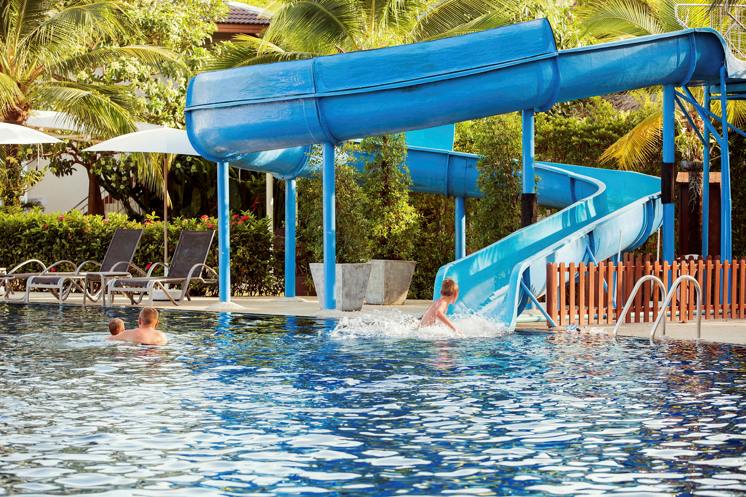Barn leker i pool med vattenrutschbana. (AI-genererad text)