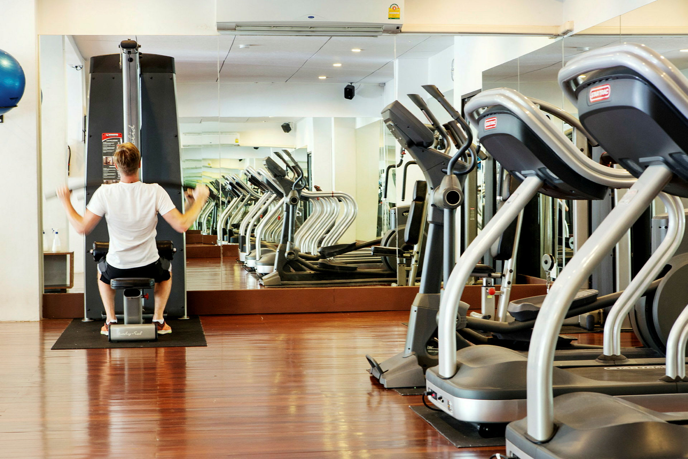 En person tränar på en maskin i ett gym. (AI-genererad text)