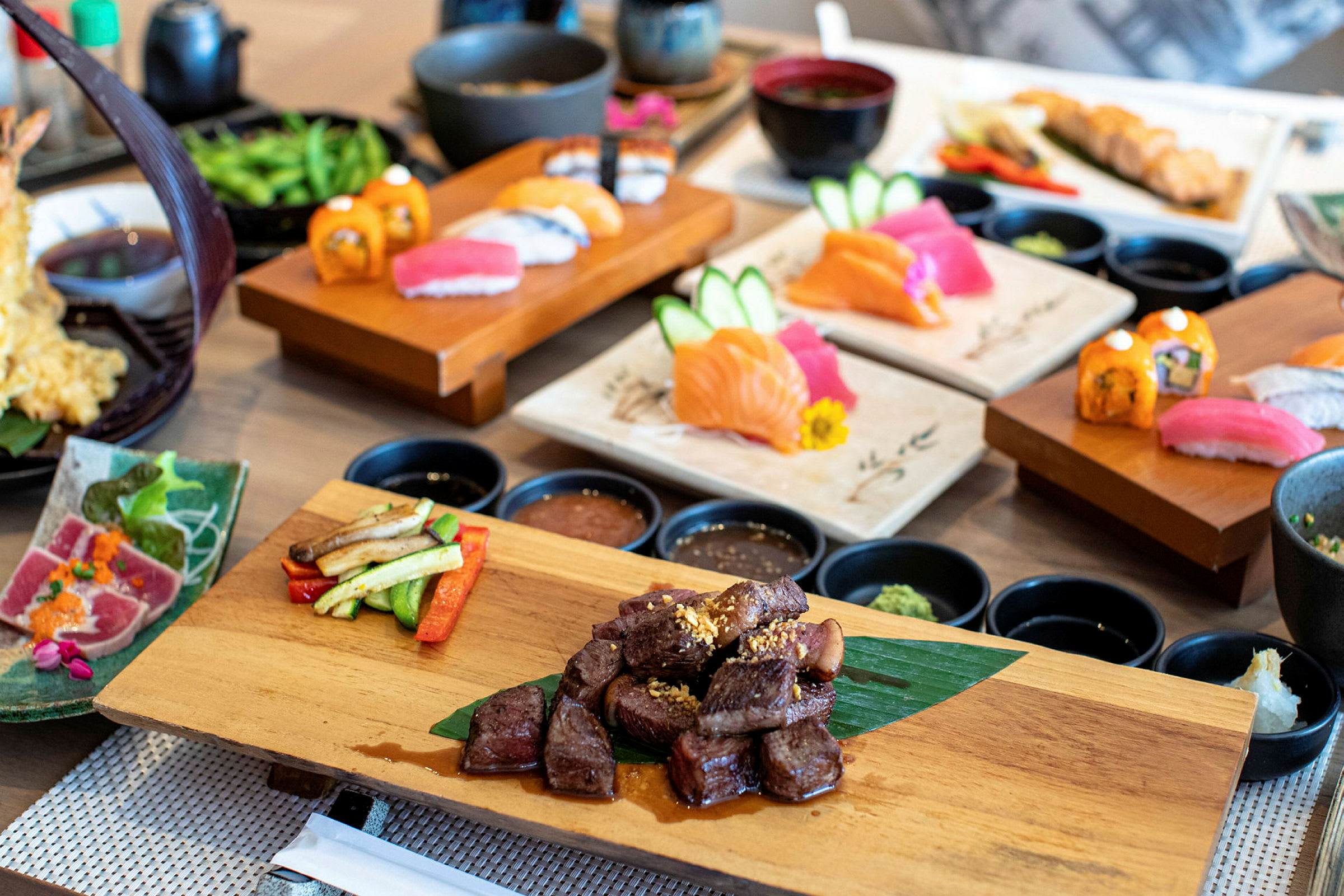 En uppsättning japanska maträtter, inklusive sushi och grillat kött. (AI-genererad text)