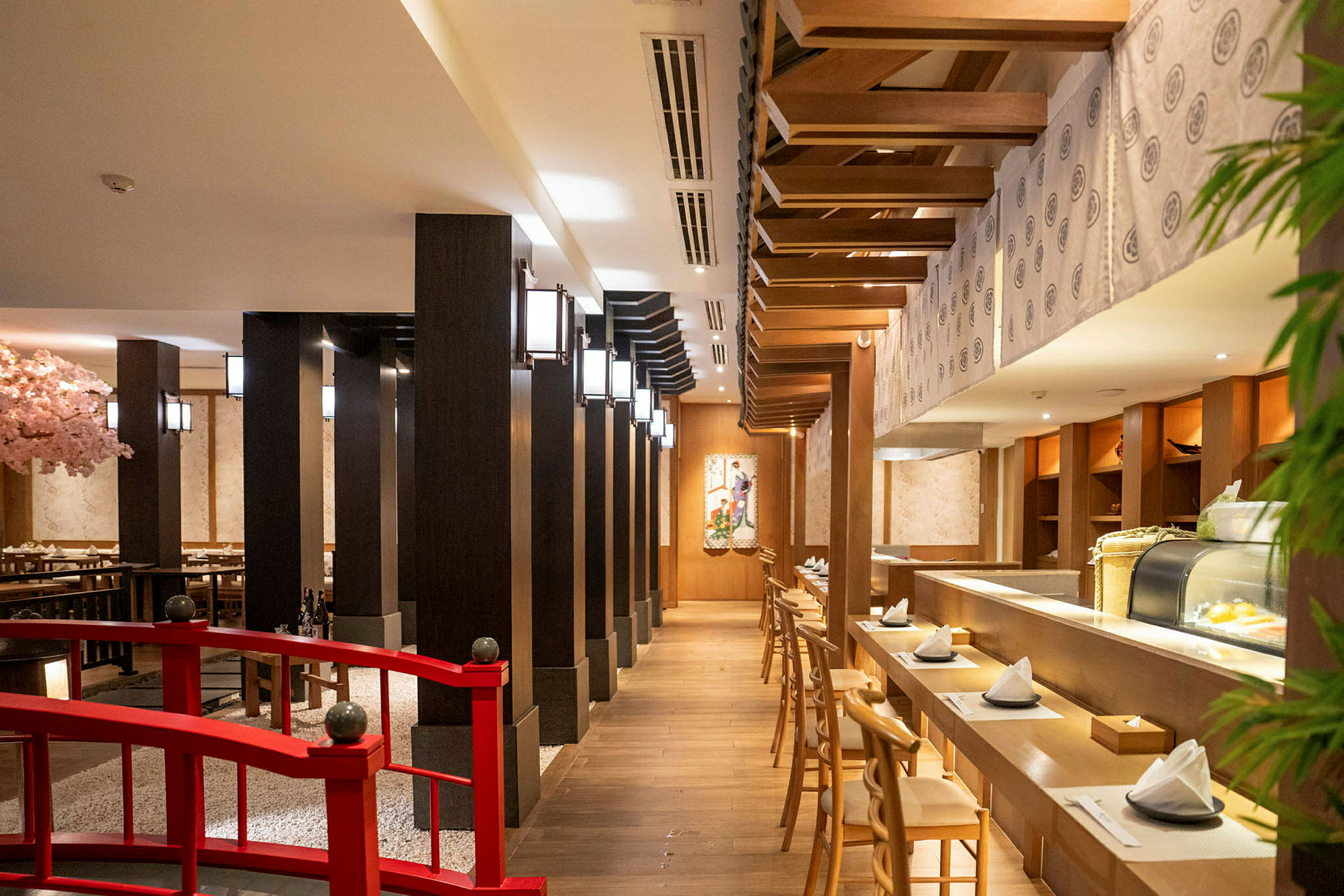 Japansk restaurang med träinteriör och bord dukade för gäster. (AI-genererad text)