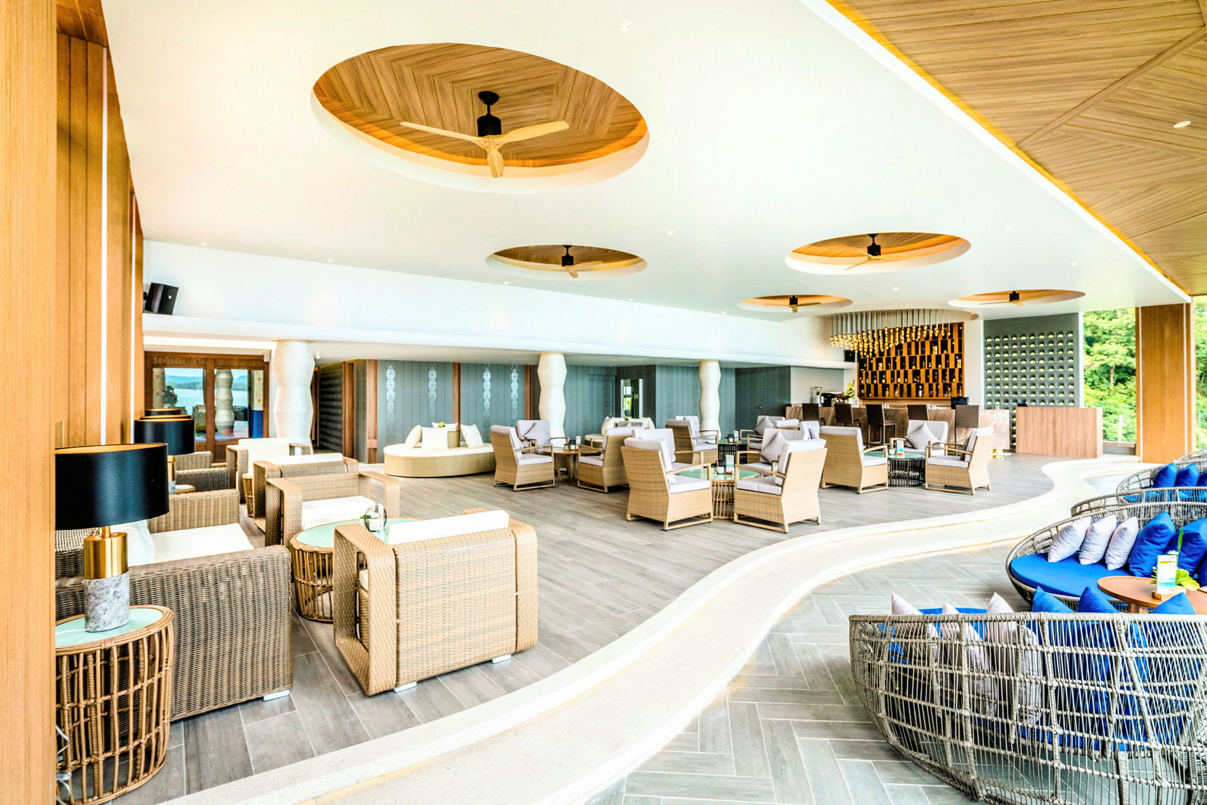 Modernt inredd lounge med rottingmöbler och elegant design. (AI-genererad text)
