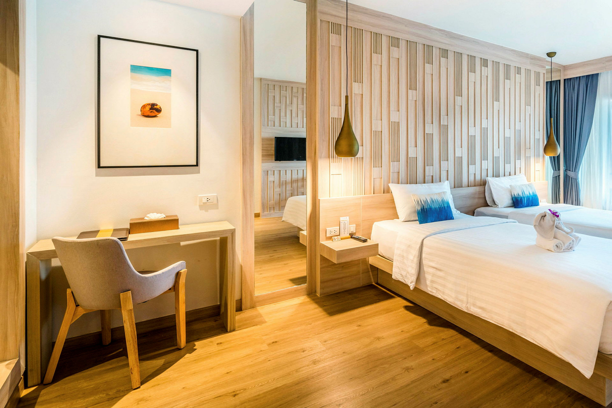 Ett hotellrum med två enkelsängar, en skrivbordshörna och en stol. (AI-genererad text)