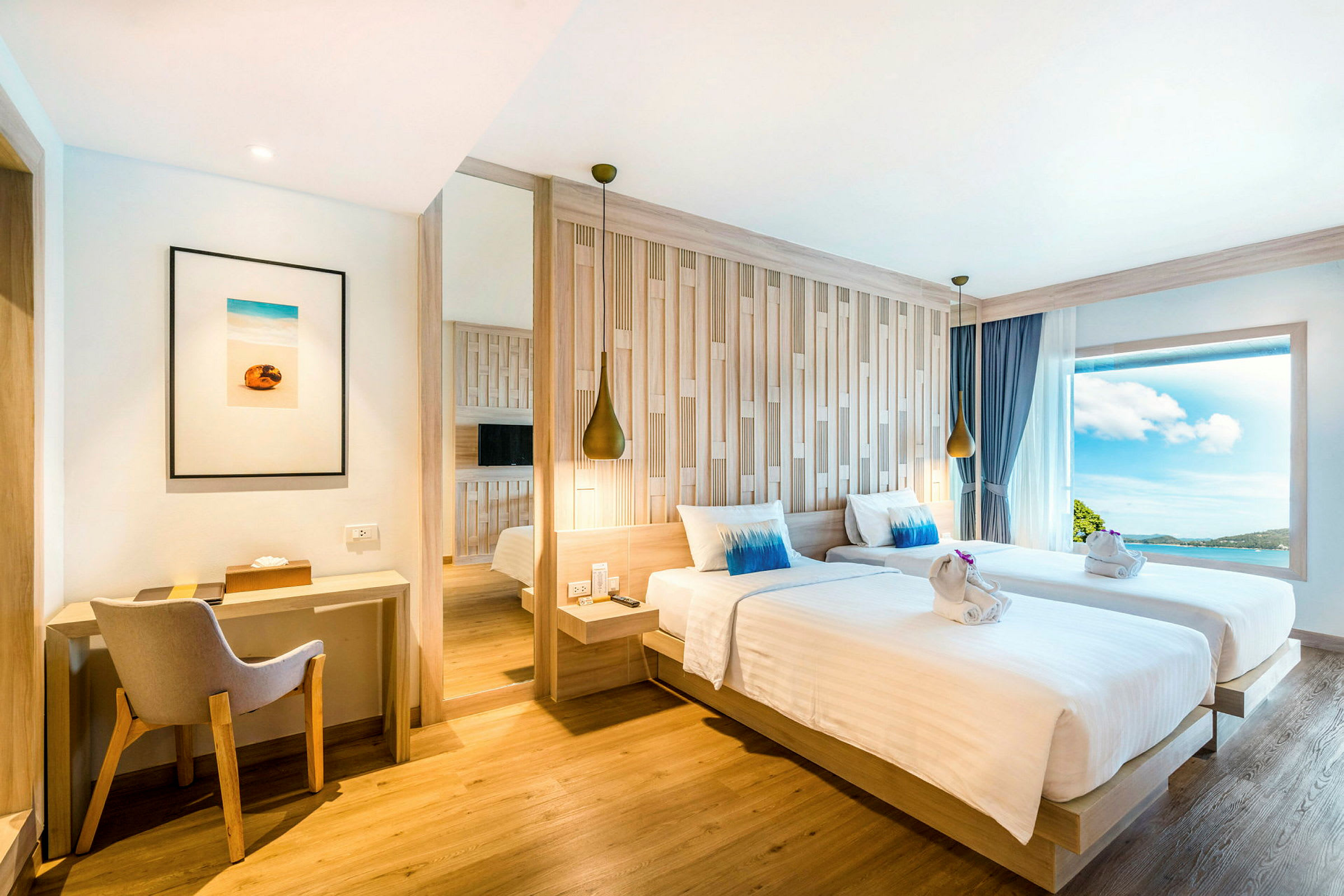 Modernt inrett hotellrum med två enkelsängar, skrivbord och stort fönster med utsikt. (AI-genererad text)