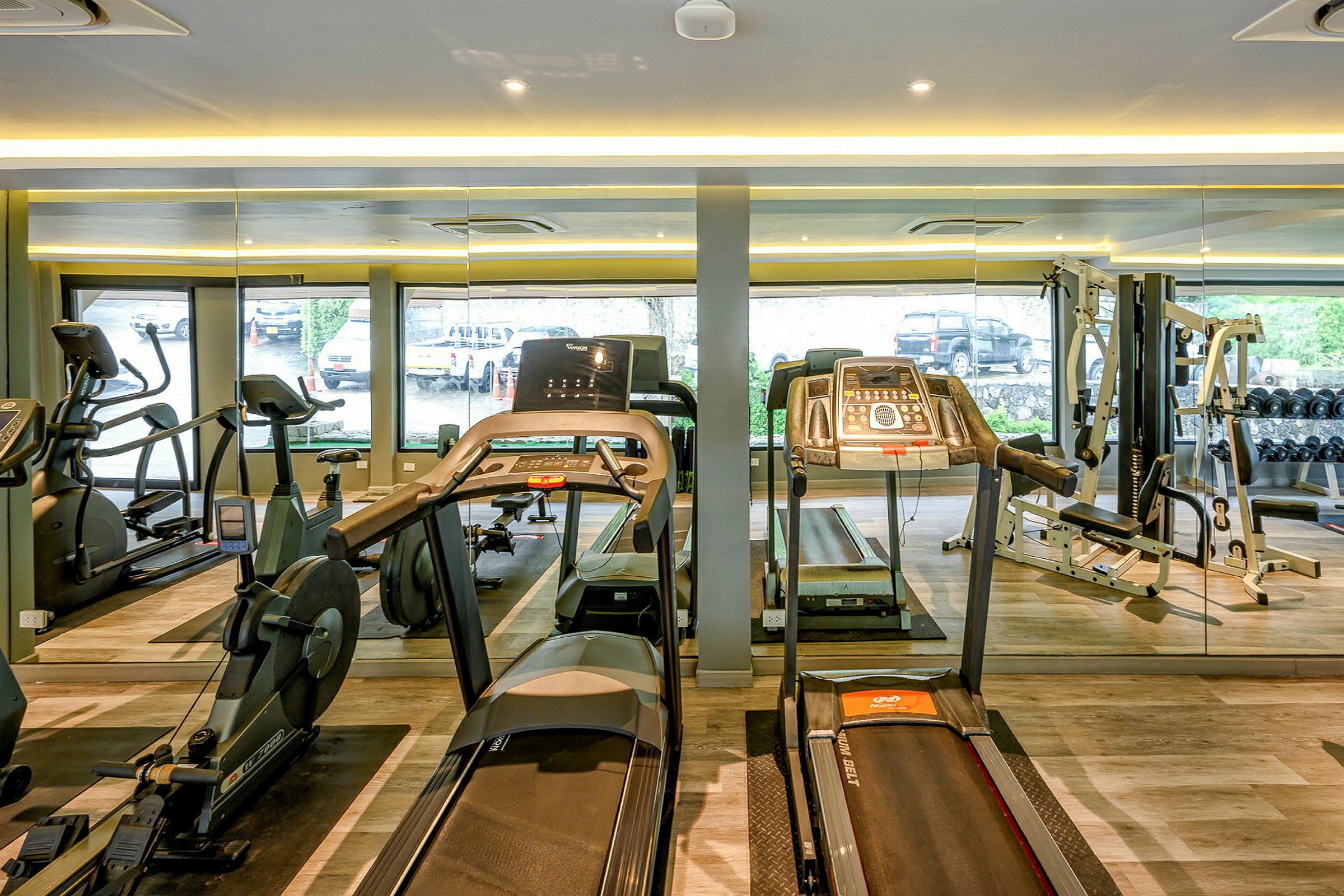 Bild av ett gym med träningsmaskiner och speglar. (AI-genererad text)