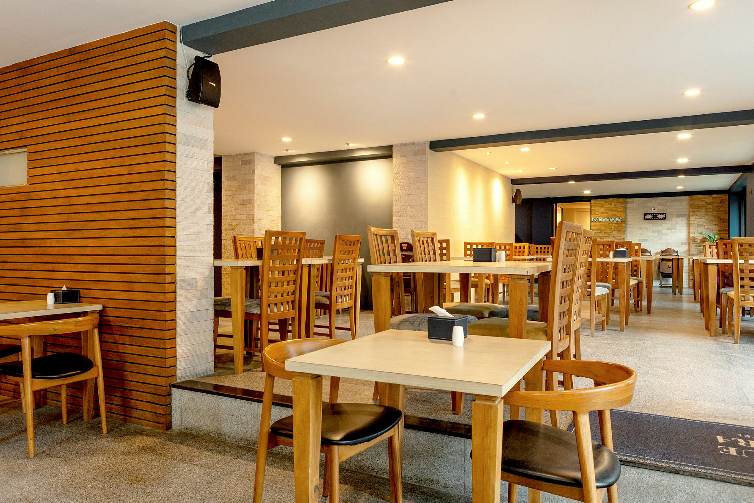 En restaurang med bord och stolar av trä samt en modern inredning. (AI-genererad text)