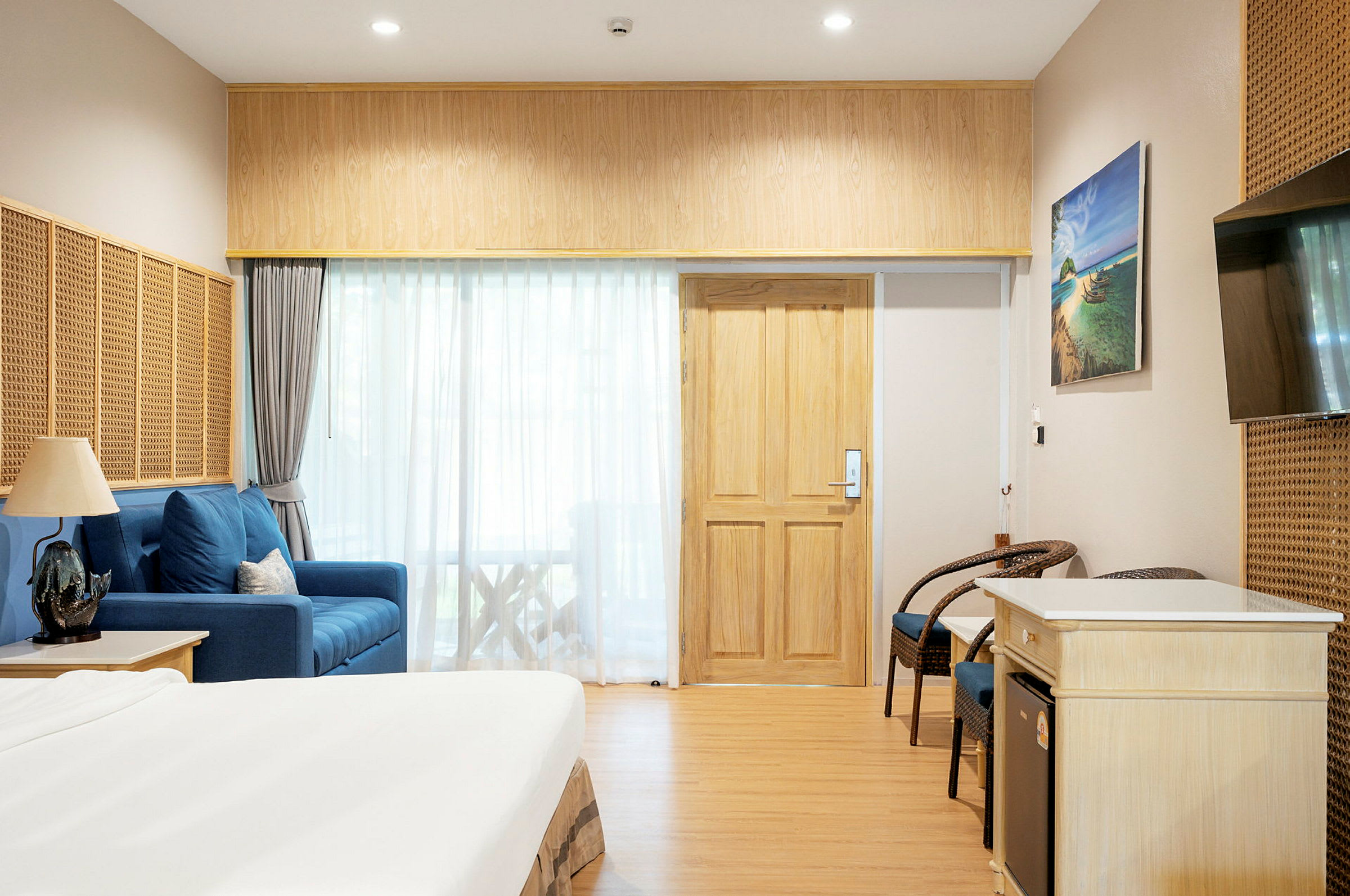 Hotellrum inrett med säng, sittmöbler och TV. (AI-genererad text)