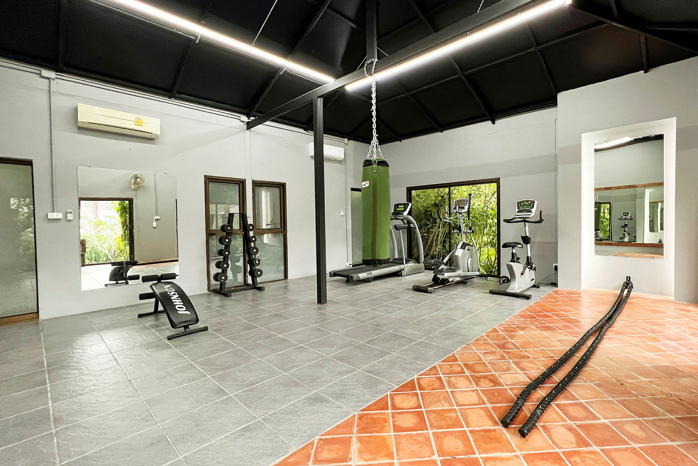 Ett gym med träningsutrustning såsom löpband, cyklar och hantlar. (AI-genererad text)