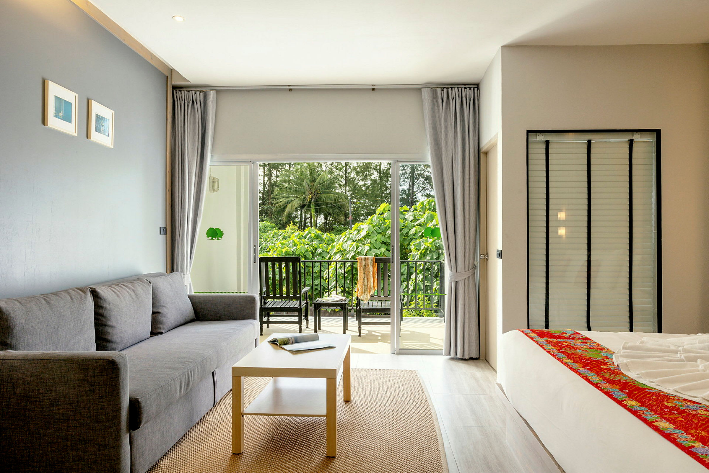 Modernt möblerat hotellrum med balkong och grön utsikt. (AI-genererad text)