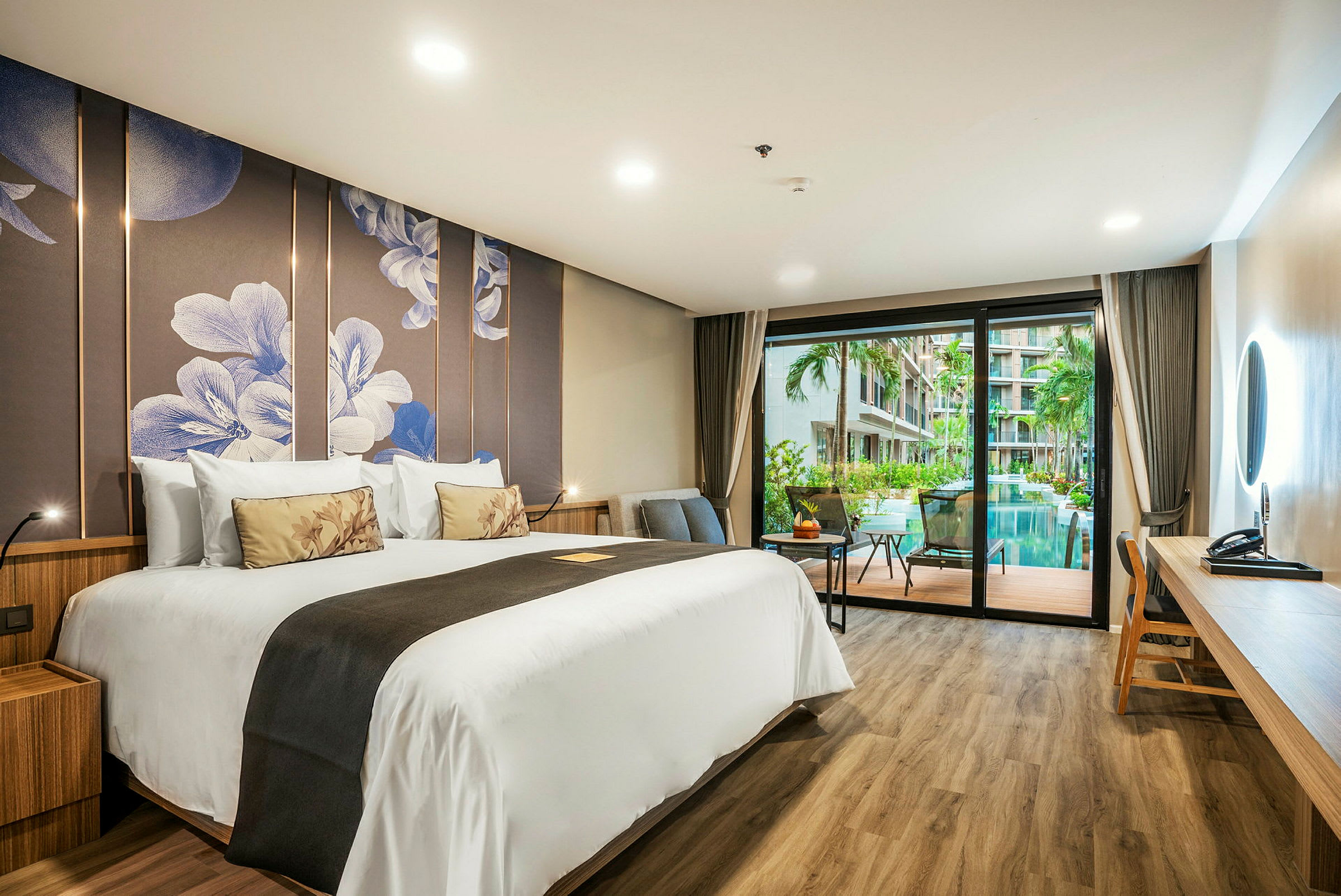 Hotellrum med stor säng, modern inredning och utsikt över pool och grönska. (AI-genererad text)