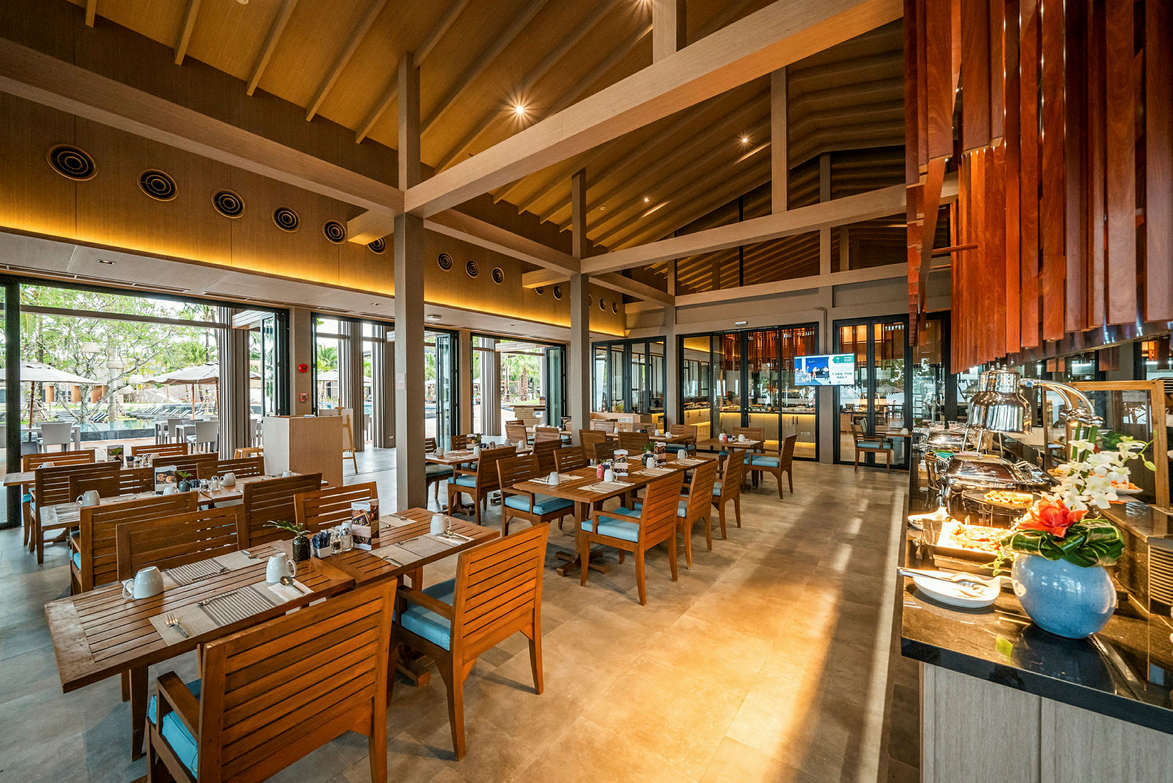 Ett rymligt restaurangområde med träinredning, sittplatser och en buffé. (AI-genererad text)