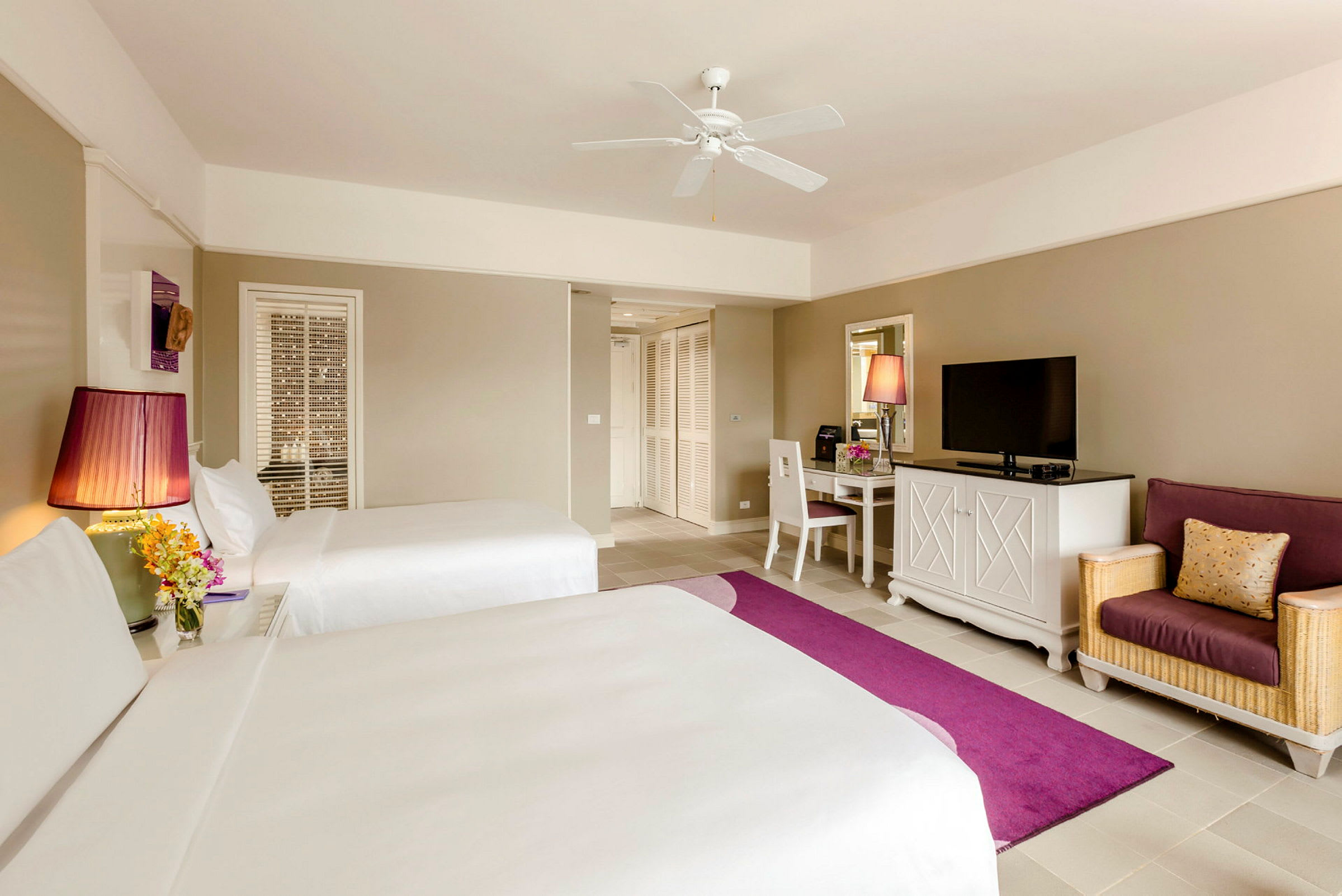 Hotellrum med två sängar, en soffa och ett skrivbord. (AI-genererad text)