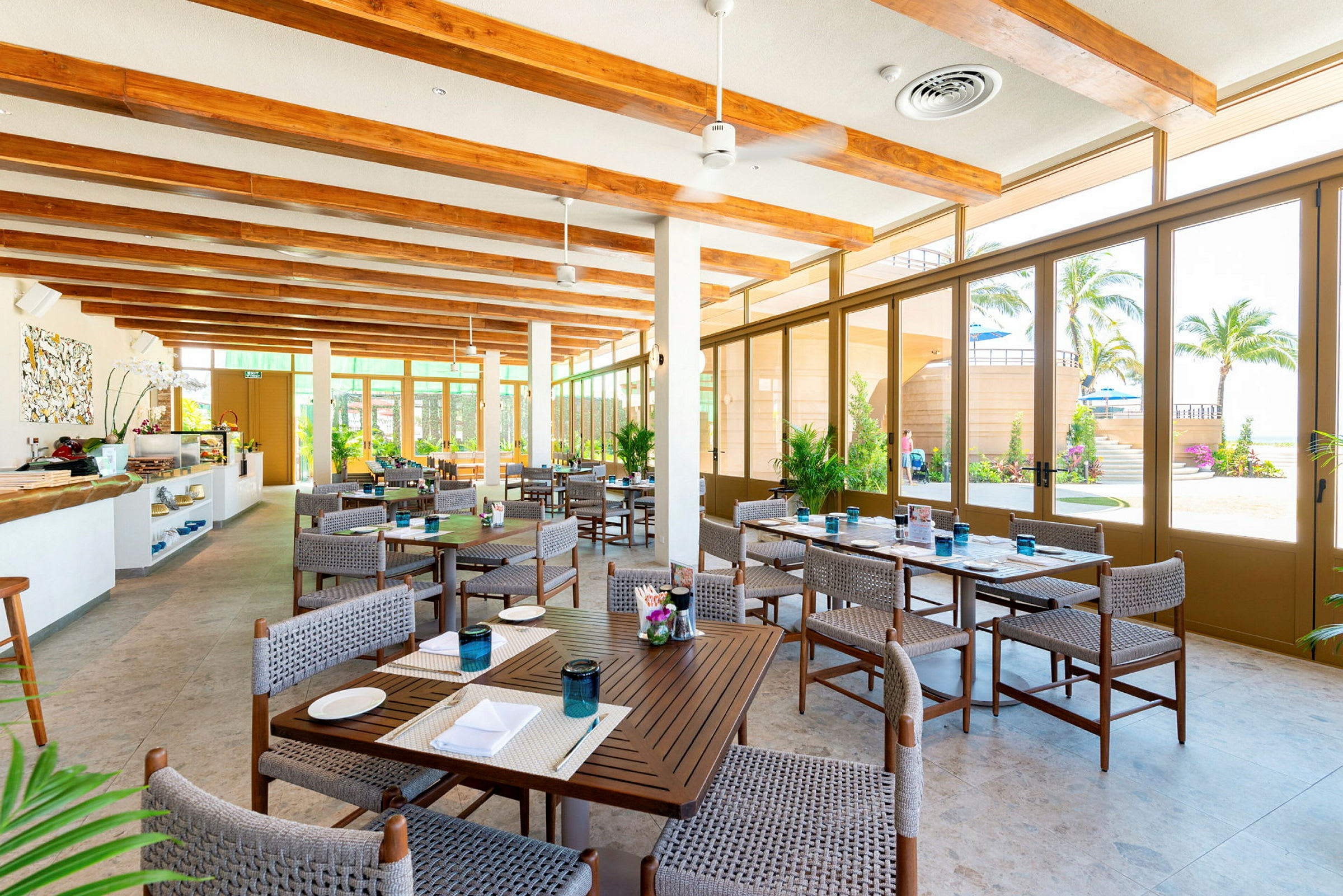 Ett ljus och rymlig restaurang med moderna möbler och stora fönster mot trädgården. (AI-genererad text)